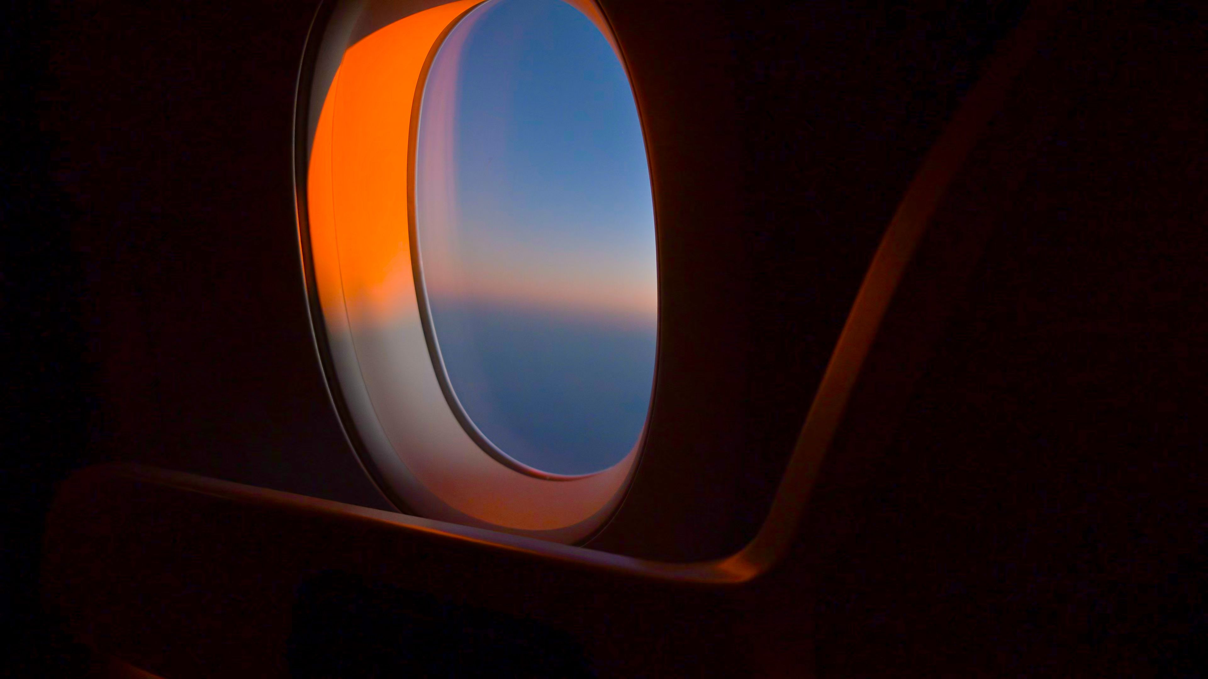 Mirando por la ventana de un avión al amanecer o al atardecer Mirando por la ventana de un avión al amanecer o al atardecer
