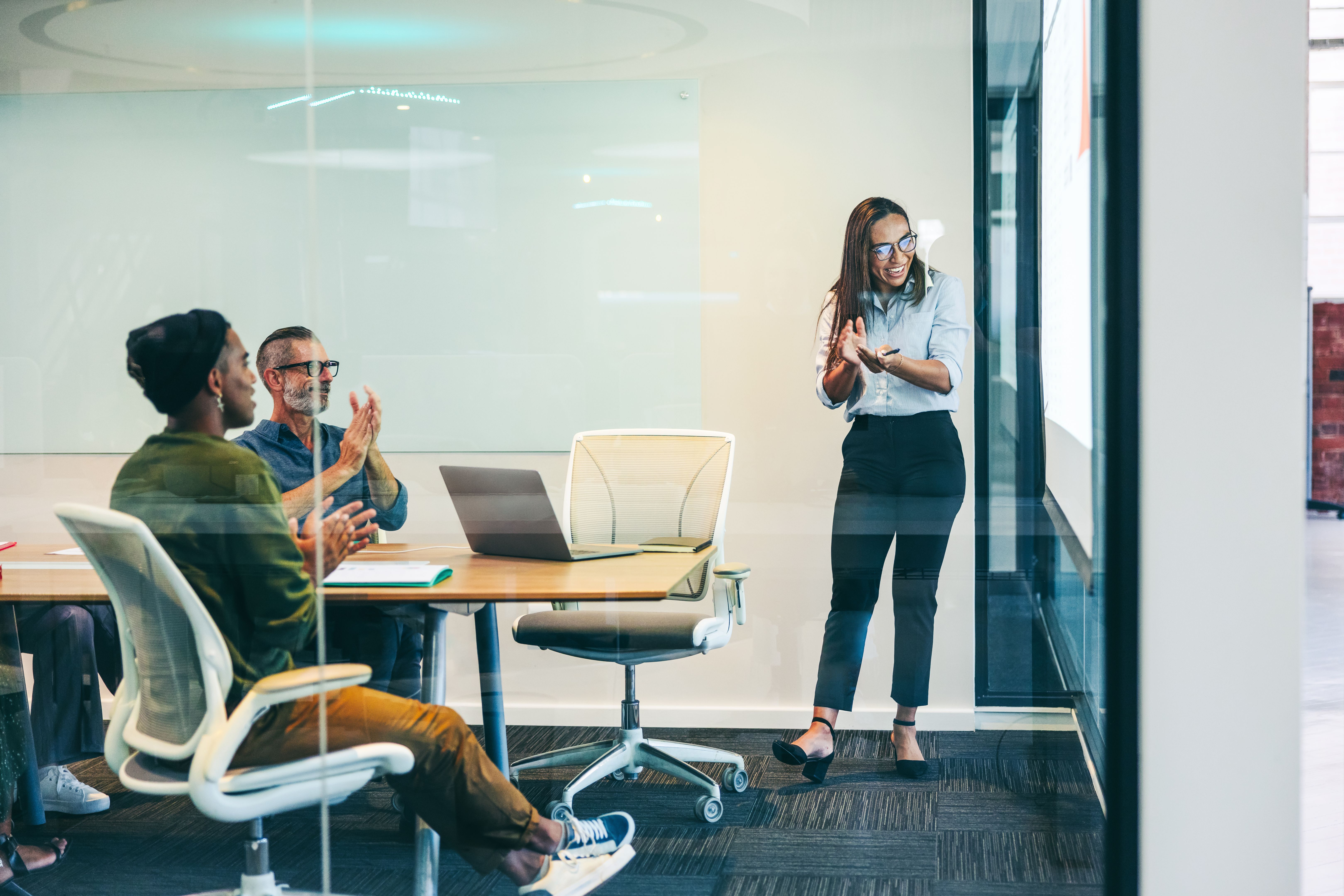 Group of colleagues applauding their success in a boardroom Group of colleagues applauding their success in a boardroom