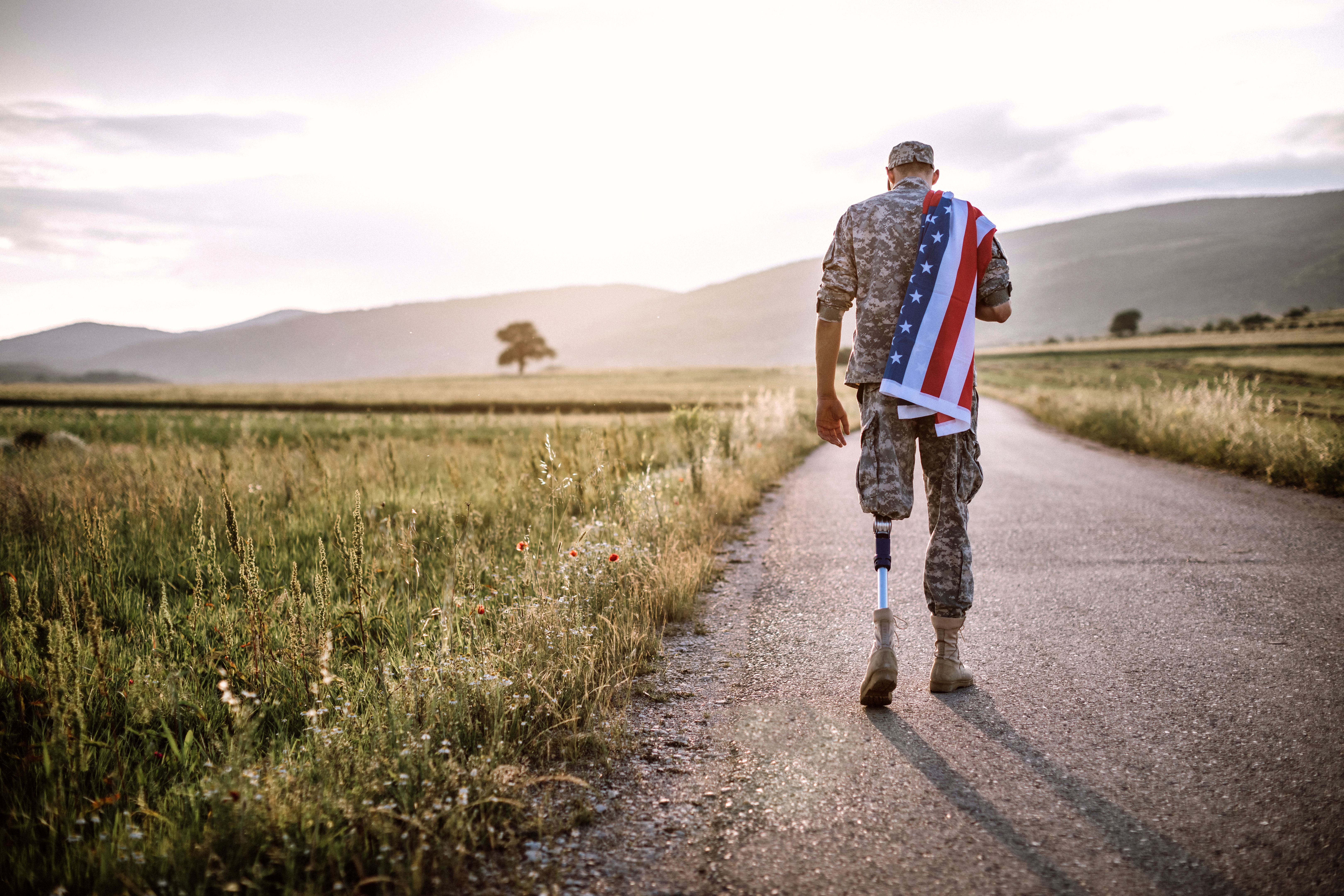 Amputee soldier with American flag on road Amputee soldier with American flag on road