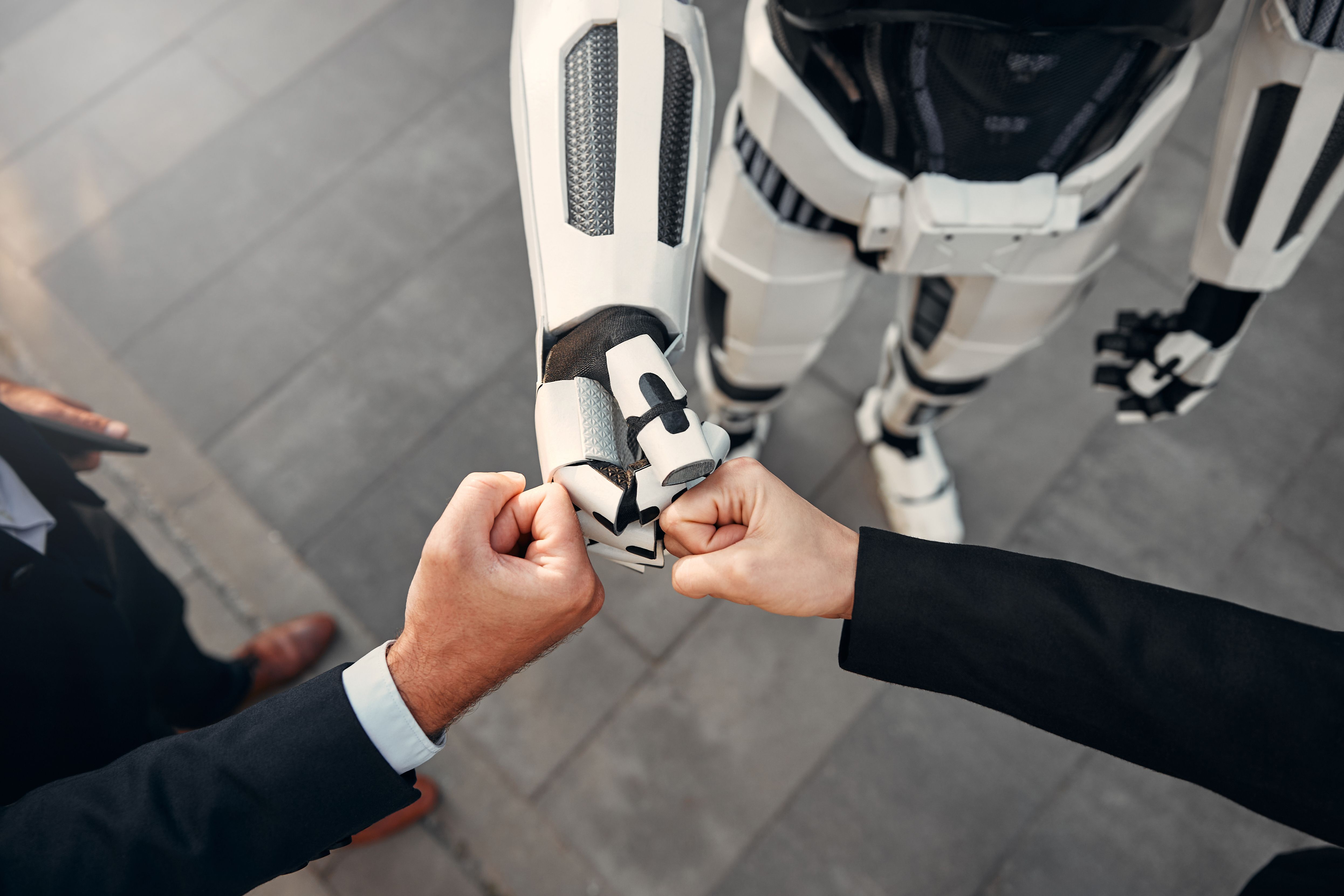 Robot with businessmen on the street near the building