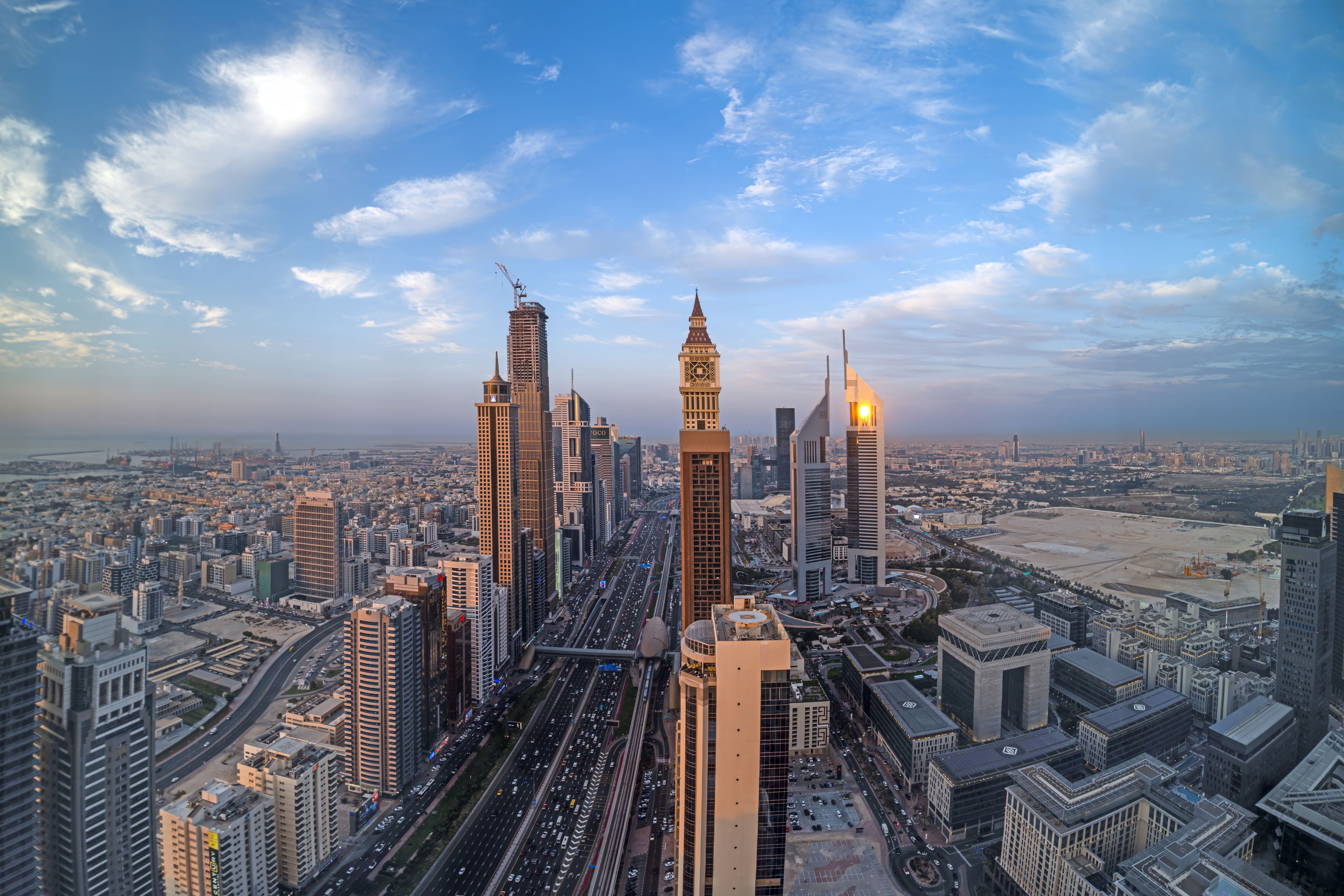 Aerial view of Sheikh Zayed Road in Dubai with skyscrapers and urban skyline under a blue sky Aerial view of Sheikh Zayed Road in Dubai with skyscrapers and urban skyline under a blue sky