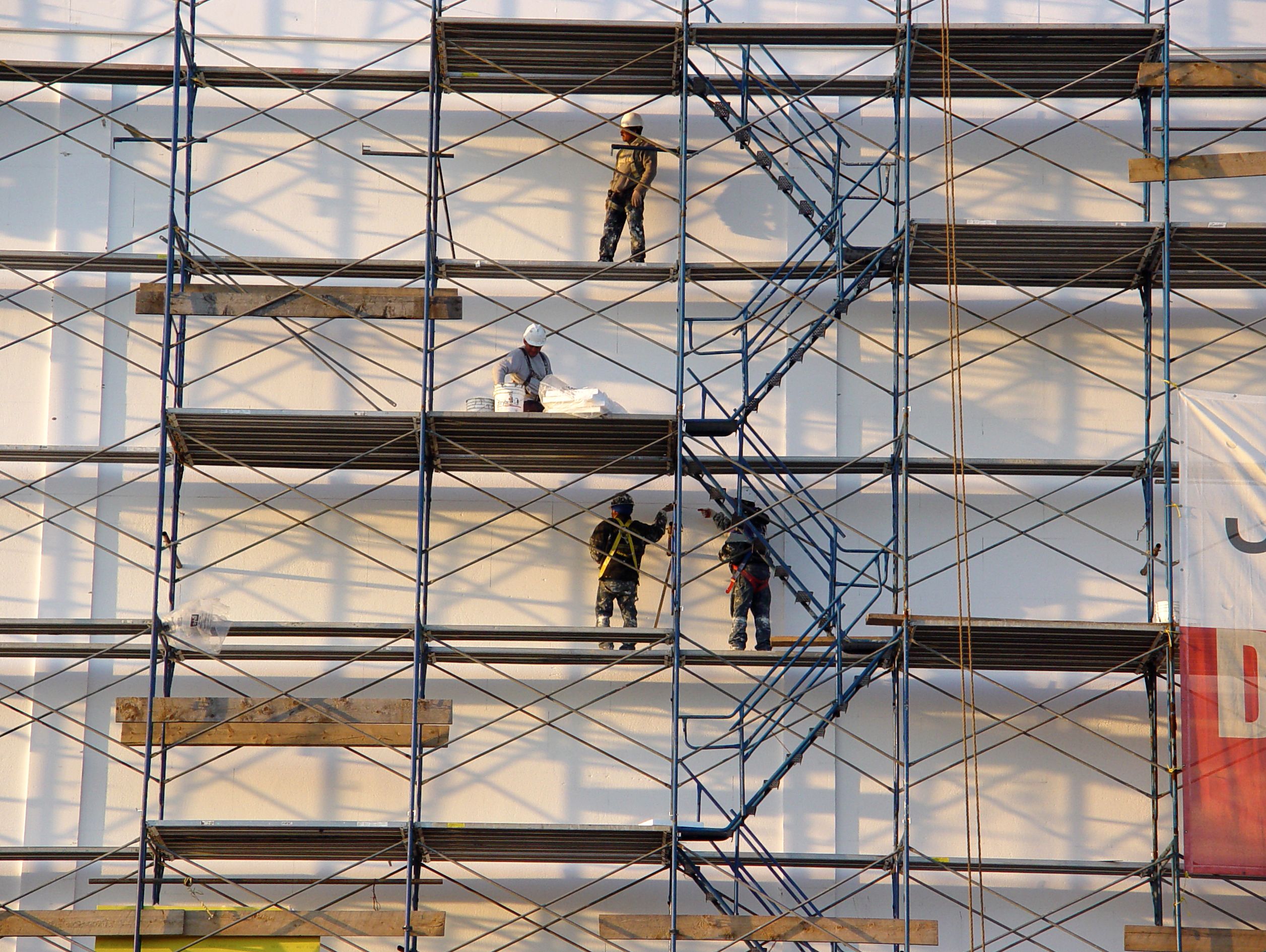 Picture of four men working on a scaffolding 