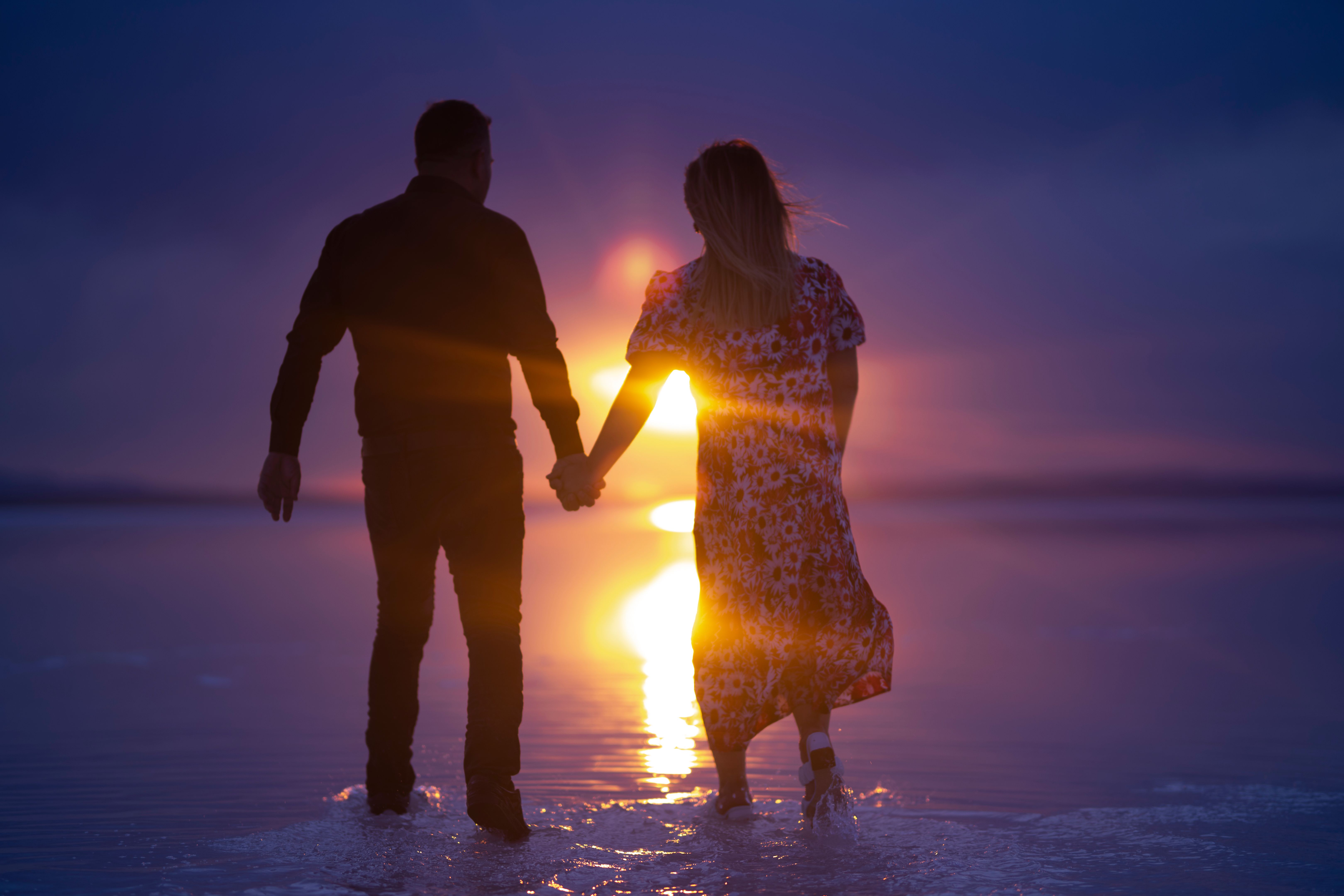 Hand in hand walk of lovers at sunset Hand in hand walk of lovers at sunset