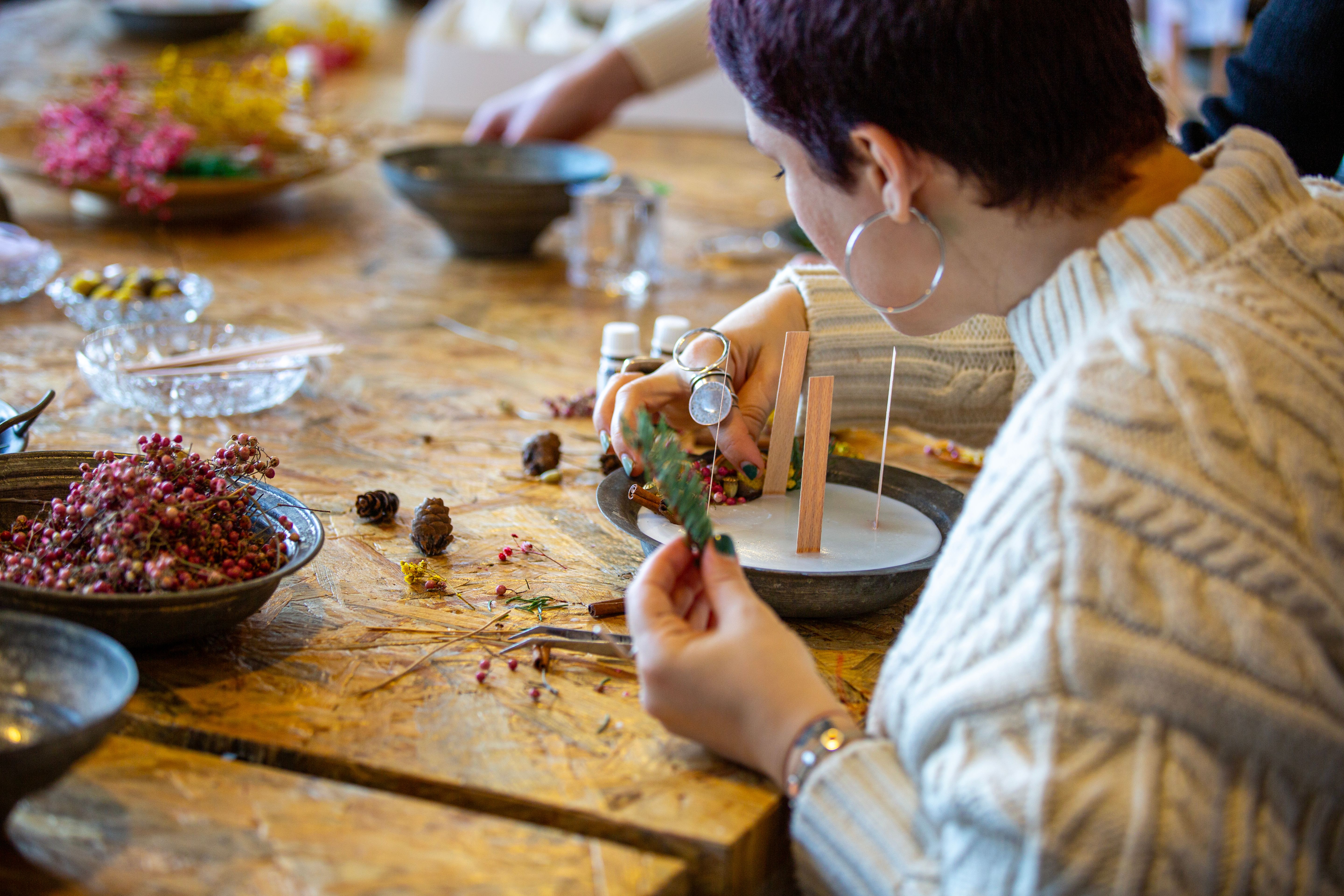 Woman making decorative aroma candle at workshop