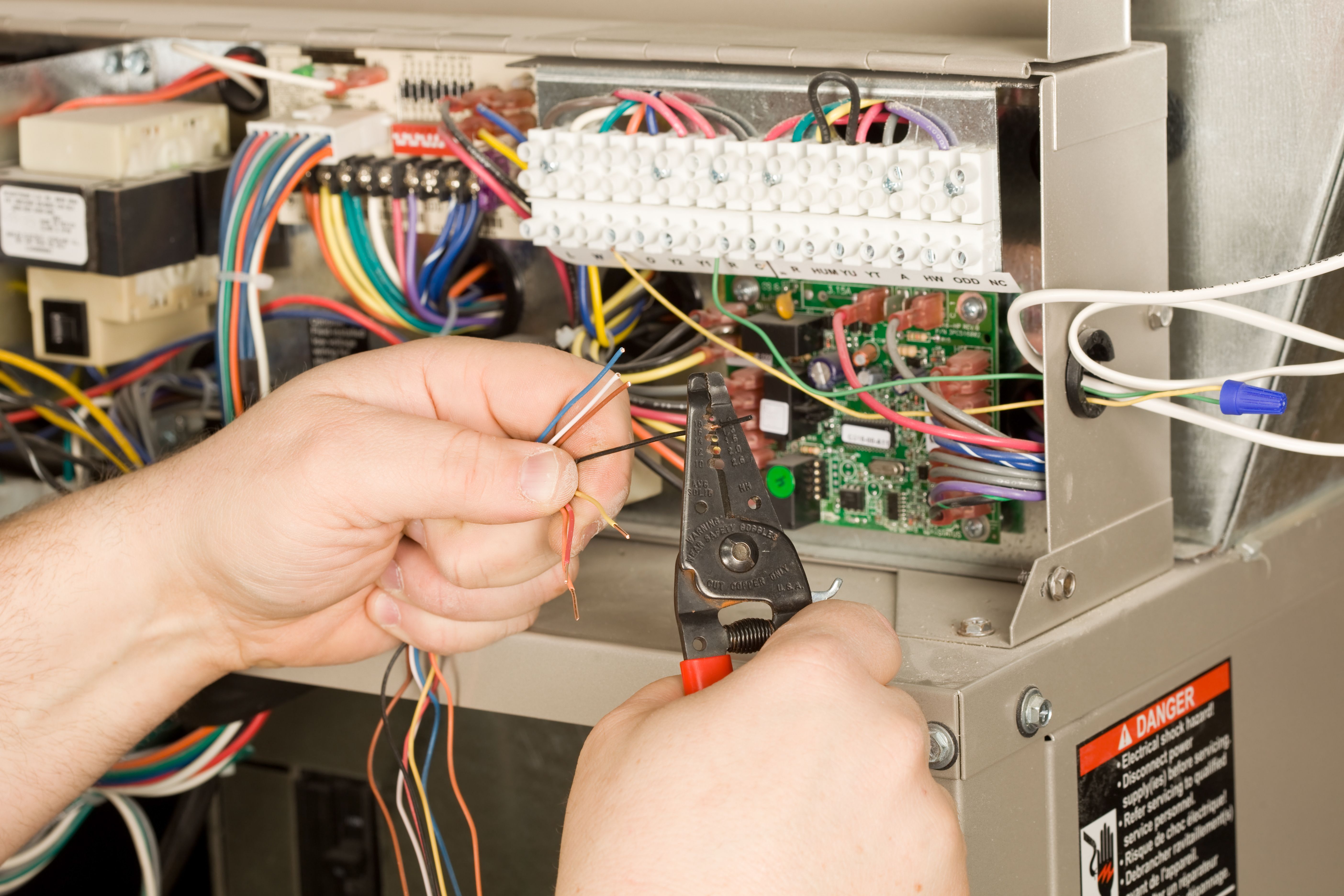 HVAC Installer Strips Small Wires for a new Residential Furnace