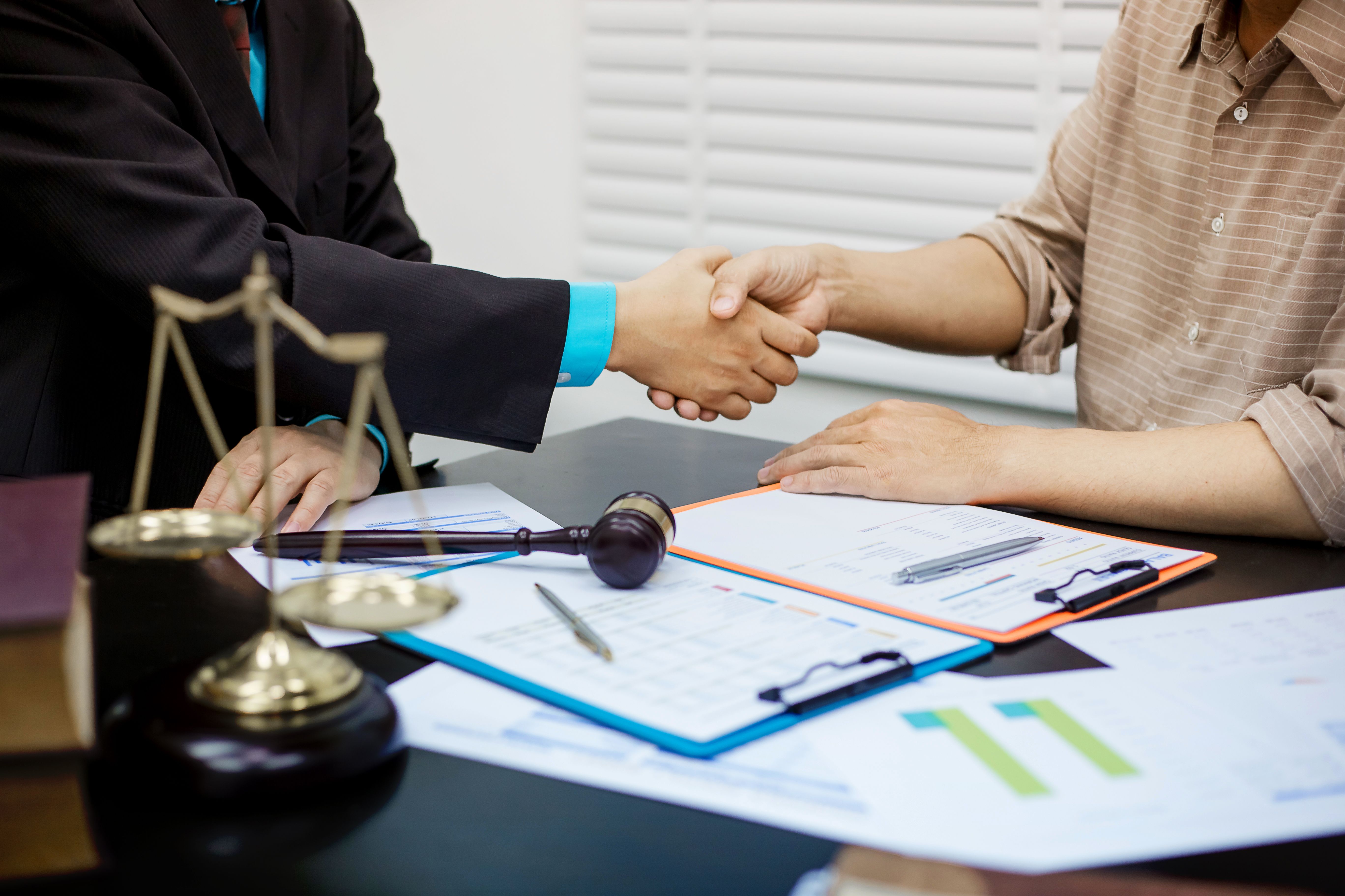 Hombre de negocios dándose la mano para sellar un acuerdo con su socio abogados o abogados discutiendo un contrato