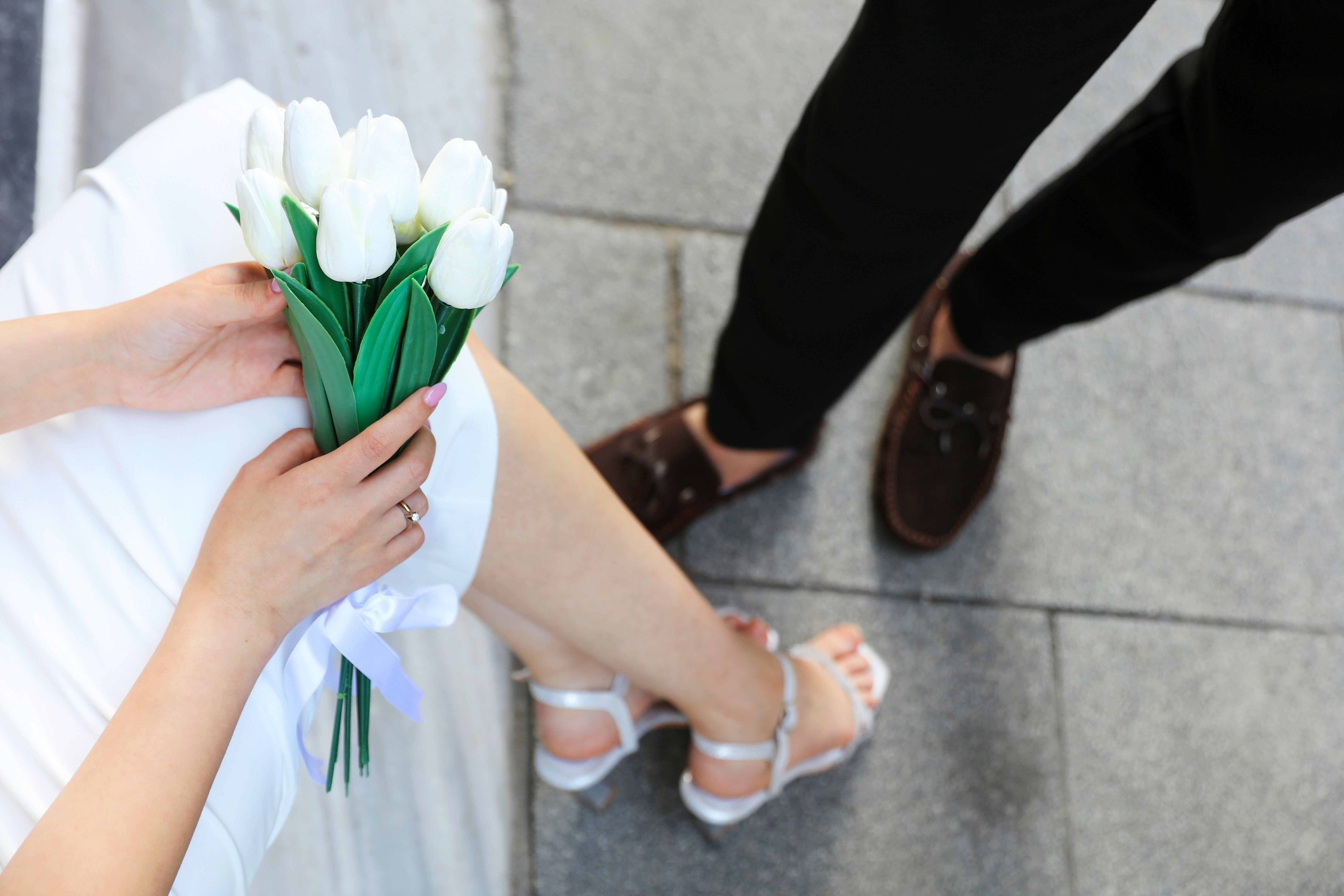 Bride hands with ring and wedding bouquet of flowers Bride hands with ring and wedding bouquet of flowers