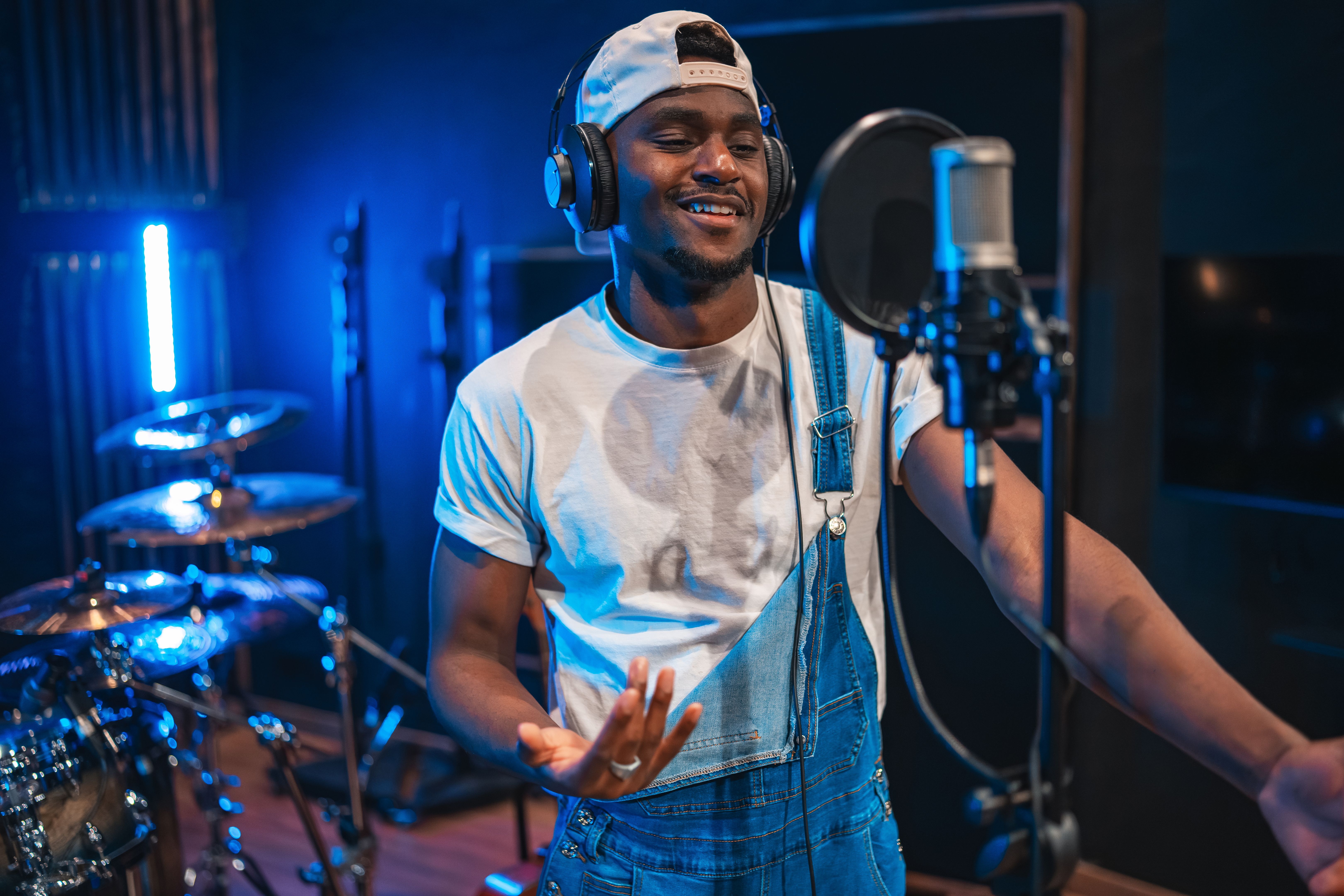 Young male singer recording new hit song in music studio