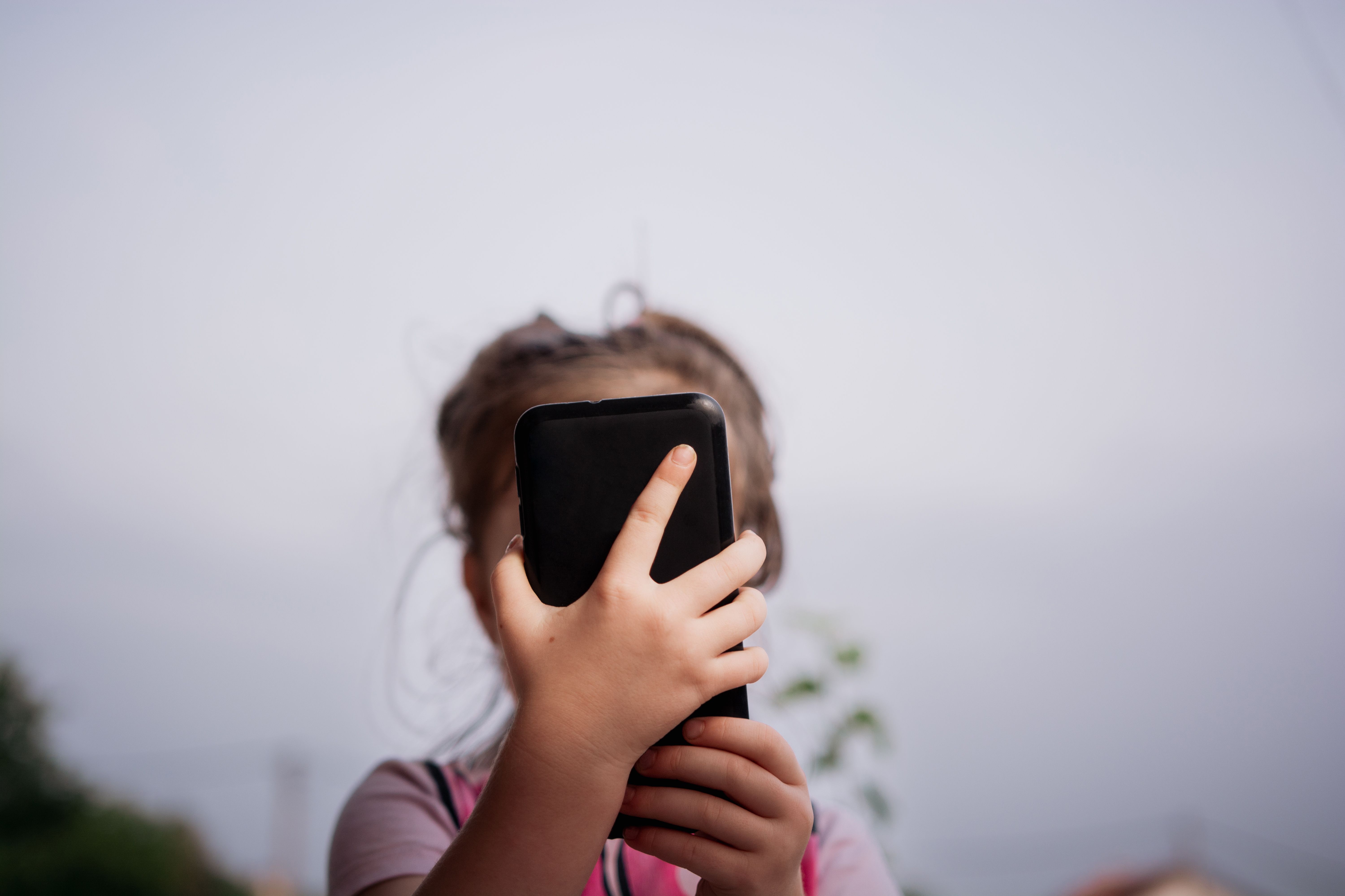 Close-up of girl using mobile phone outdoors