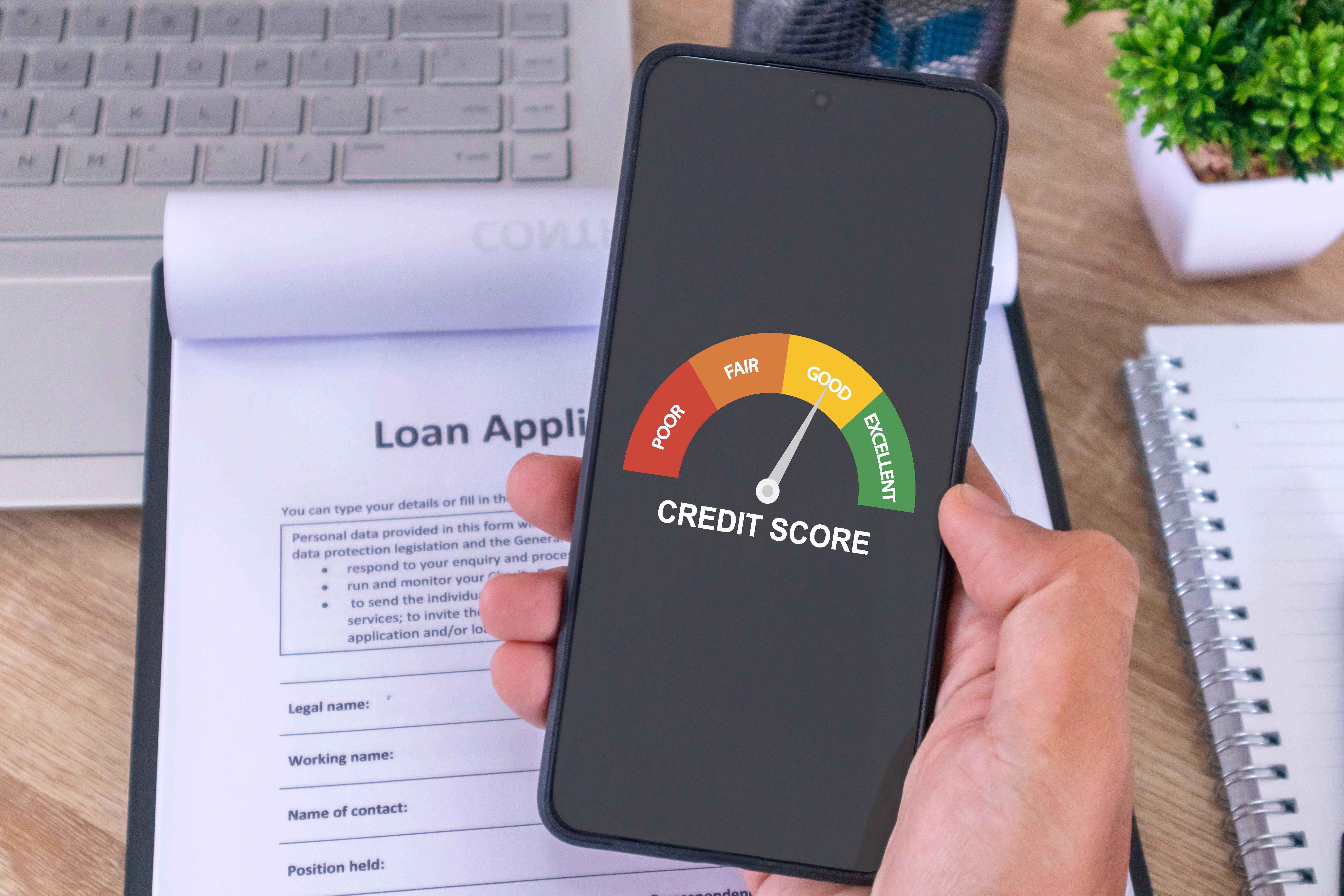 Male hand holding a cellphone to check his credit score to apply for a loan to the bank