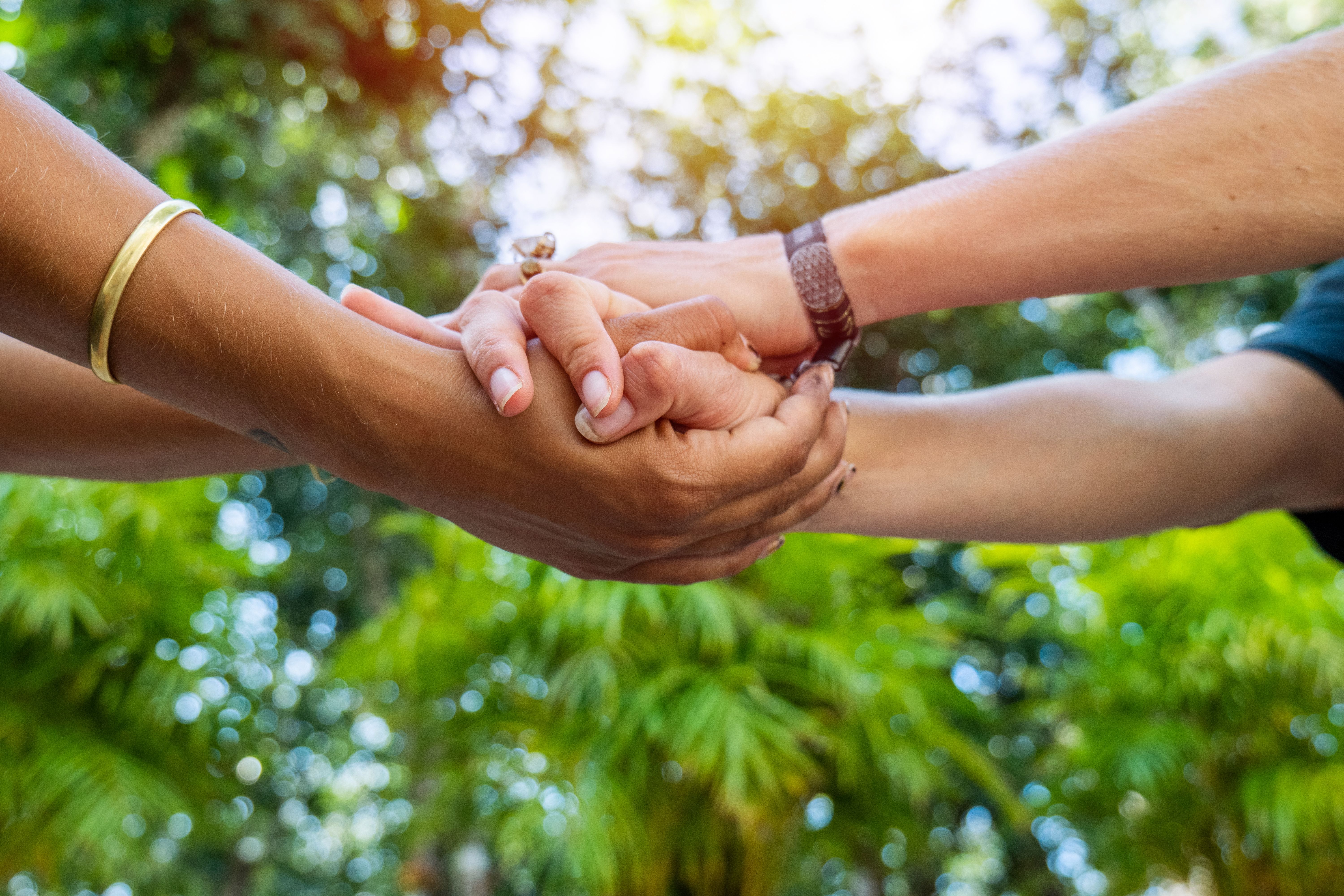 Shot of two females holding hands, diversity in skin color