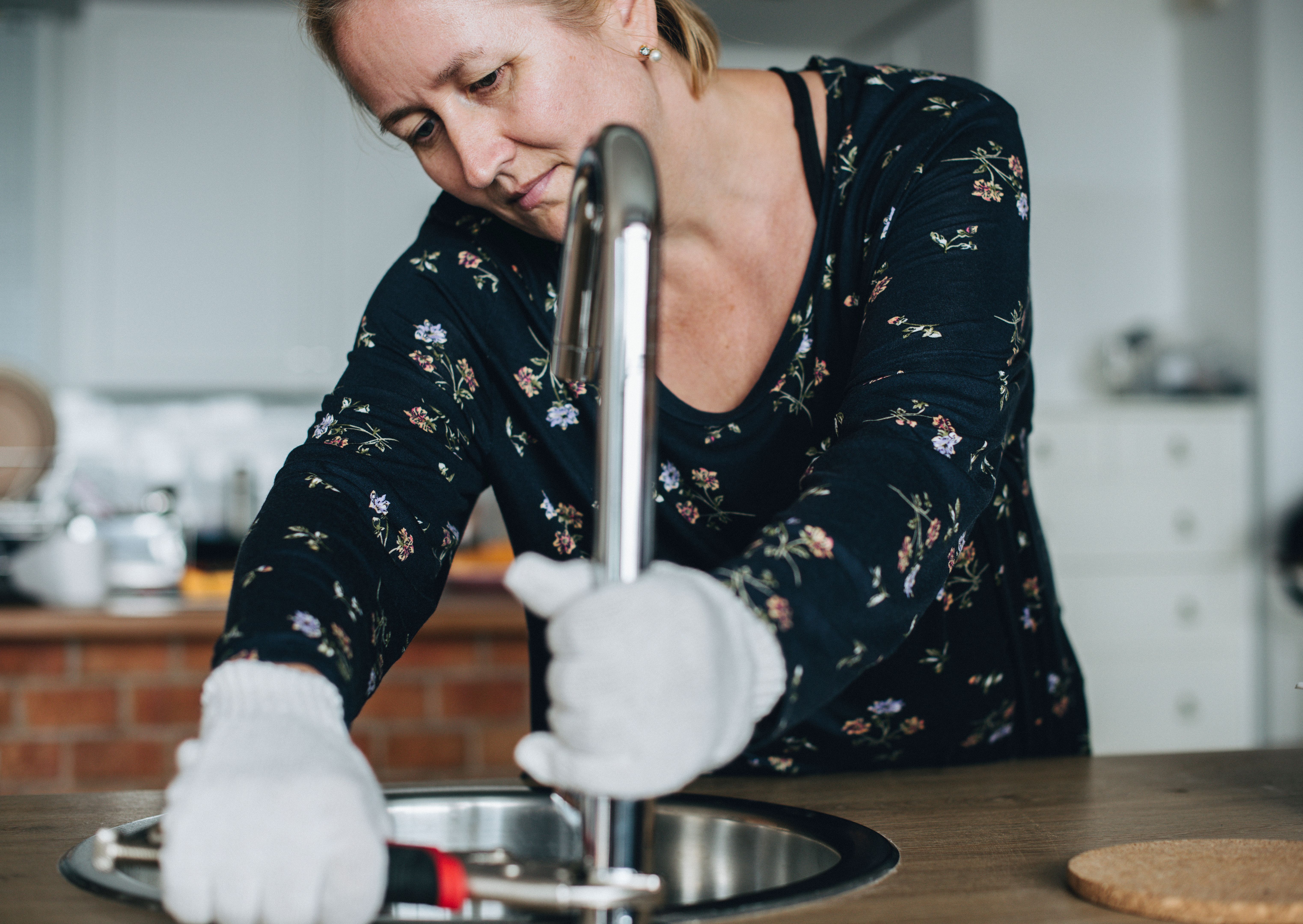 Handy woman fixing the faucet