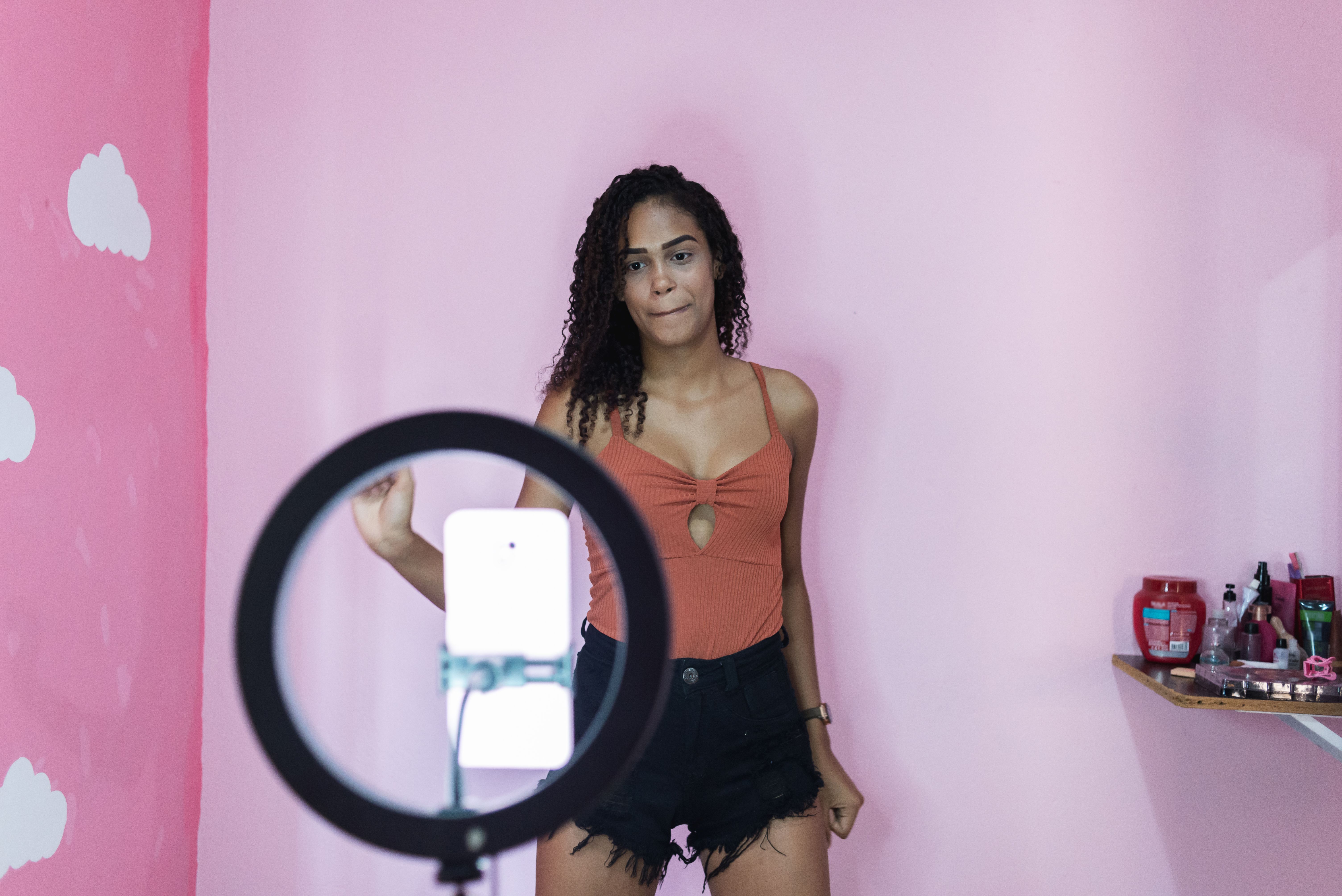 Black young woman filming herself dancing at home to share on social media