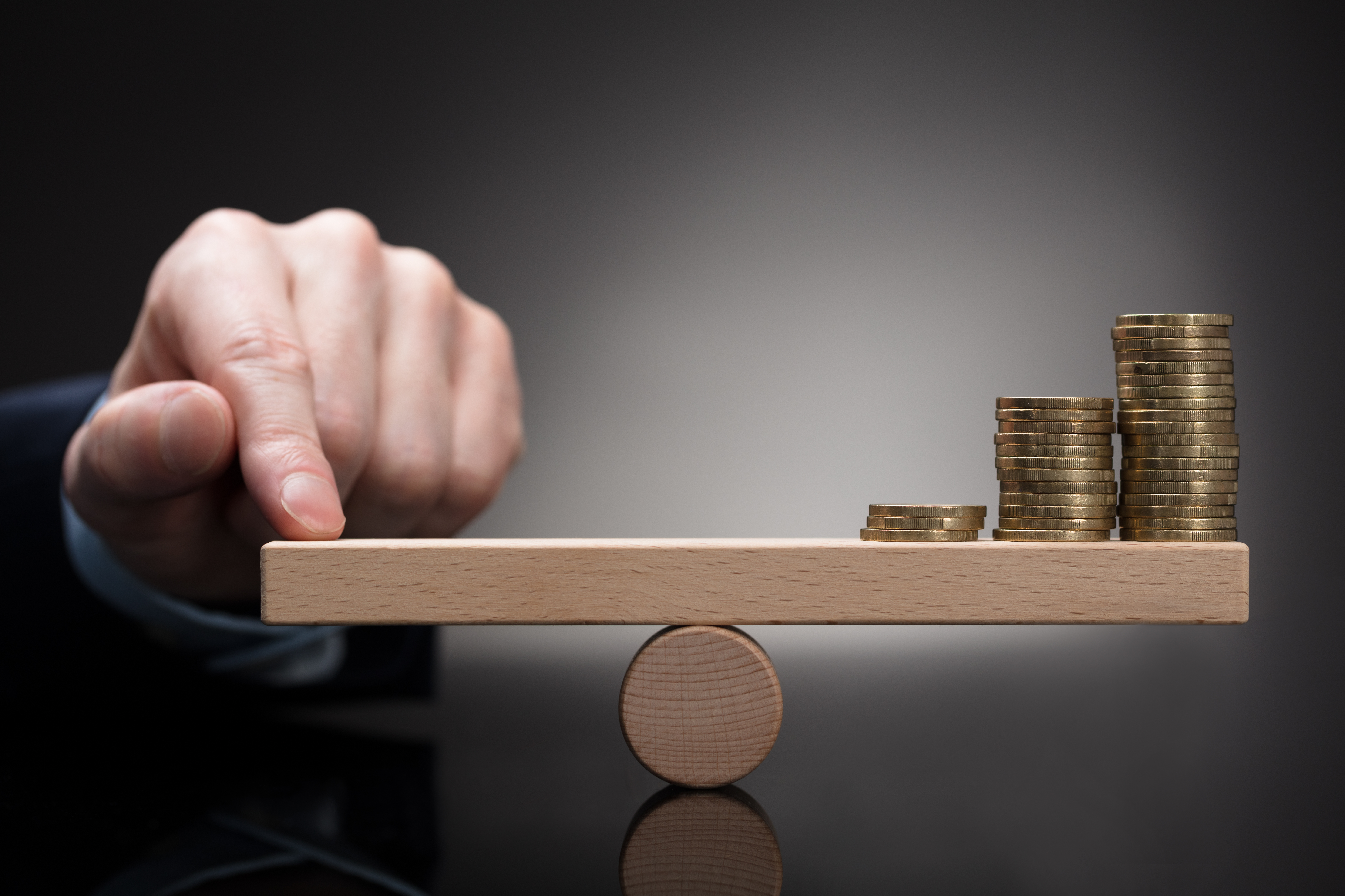 Finger Balancing Stacked Coins On Seesaw