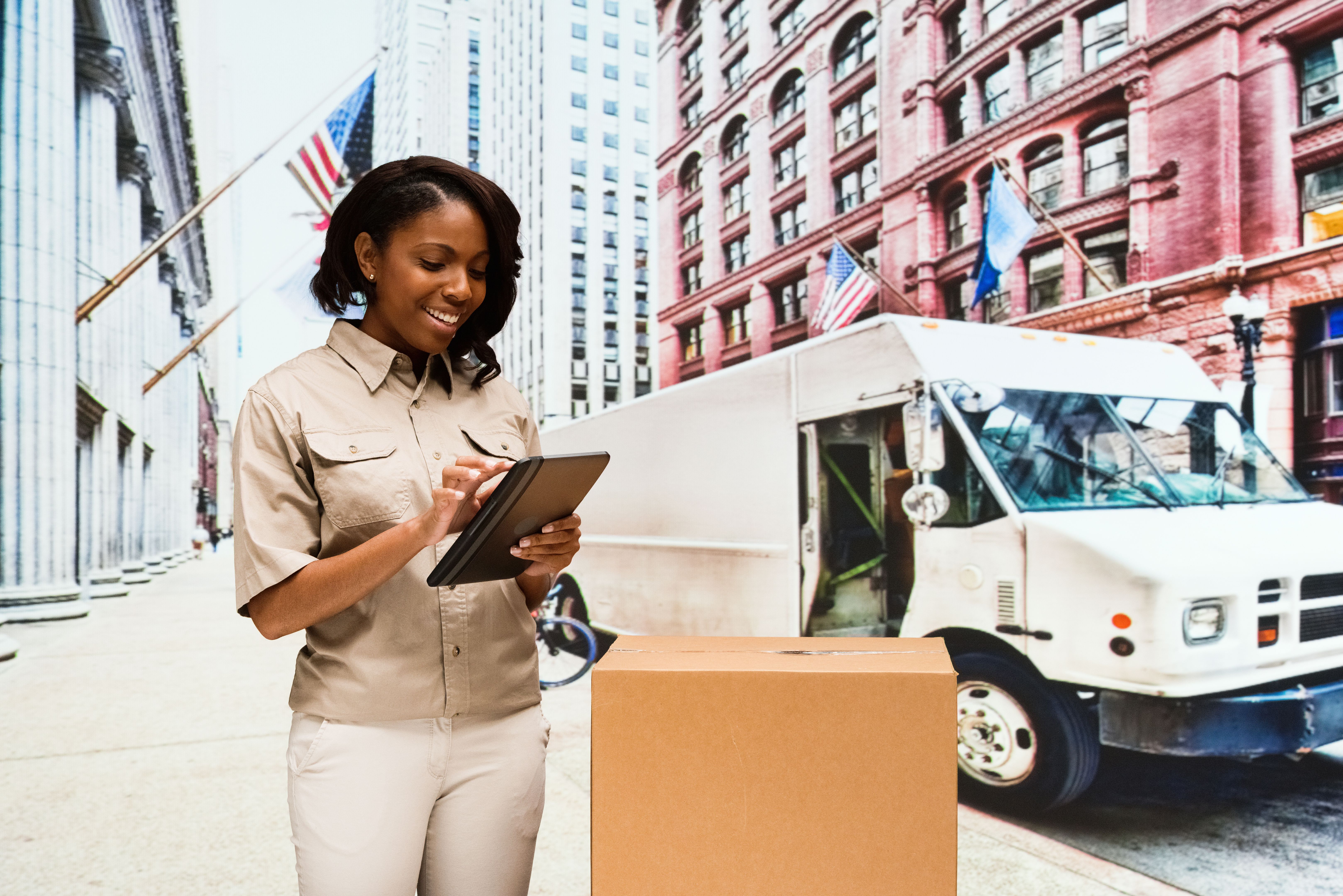 Smiling delivery person using tablet outdoors