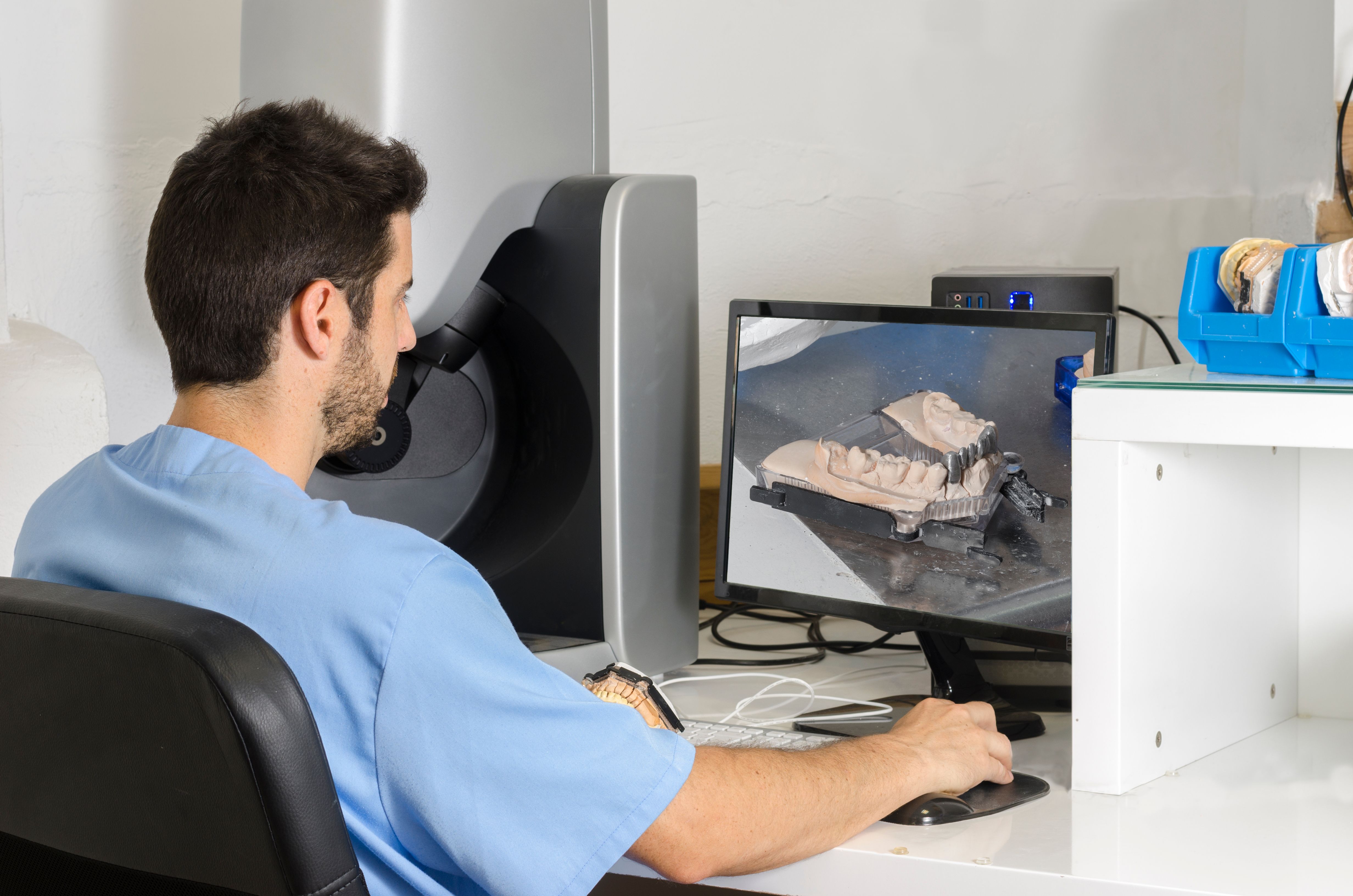Atractivo dentista trabaja con la computadora en el laboratorio.