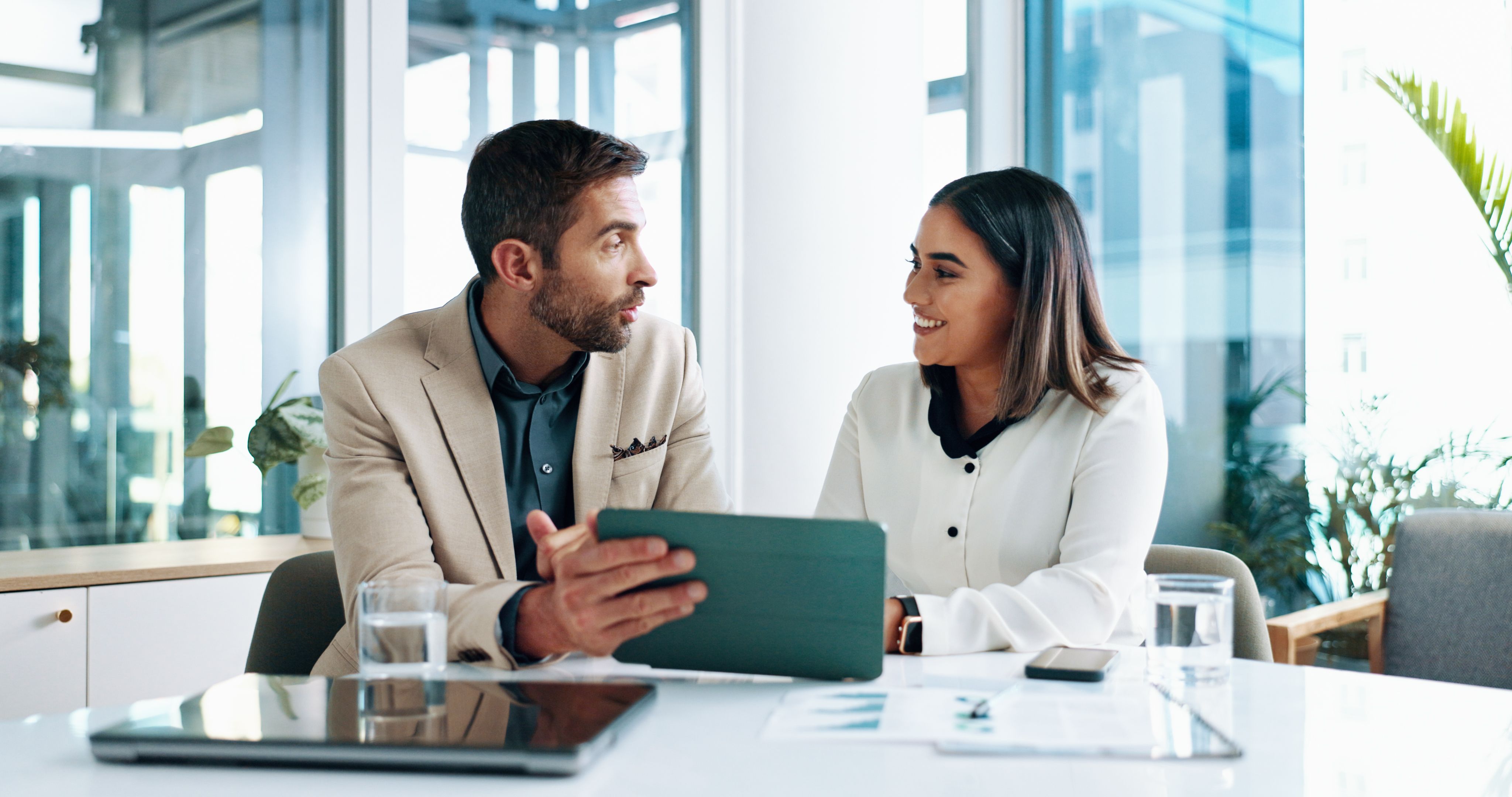 Smile, business and people on tablet in office of planning, finance document and company growth. Staff, discussion and paperwork of online information, profit graph and investment report and feedback
