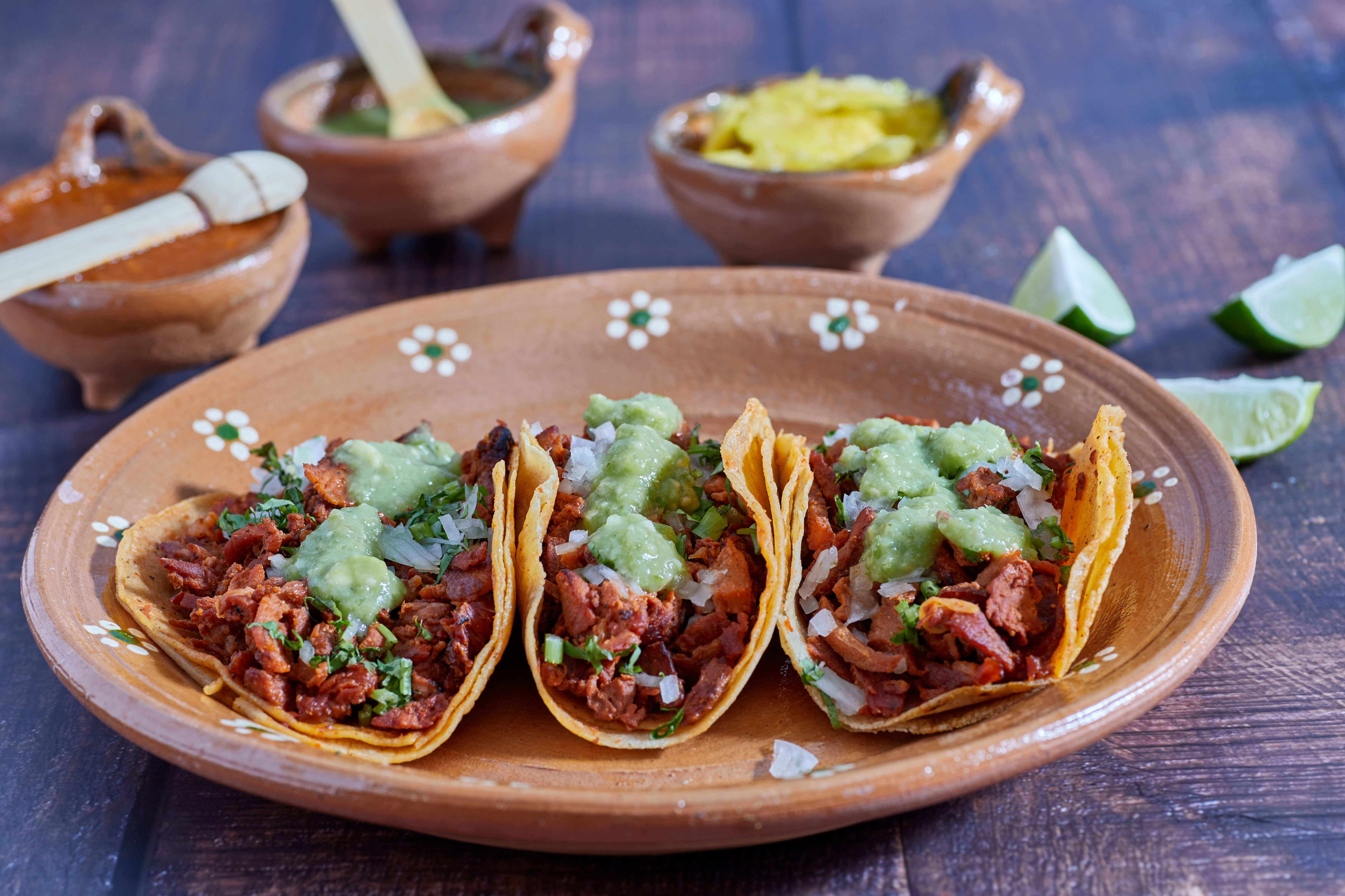 Tacos al pastor, cuisine traditionnelle mexicaine, avec oignon, coriandre, ananas, sauce rouge ou guacamole. Tacos al pastor, cuisine traditionnelle mexicaine, avec oignon, coriandre, ananas, sauce rouge ou guacamole.