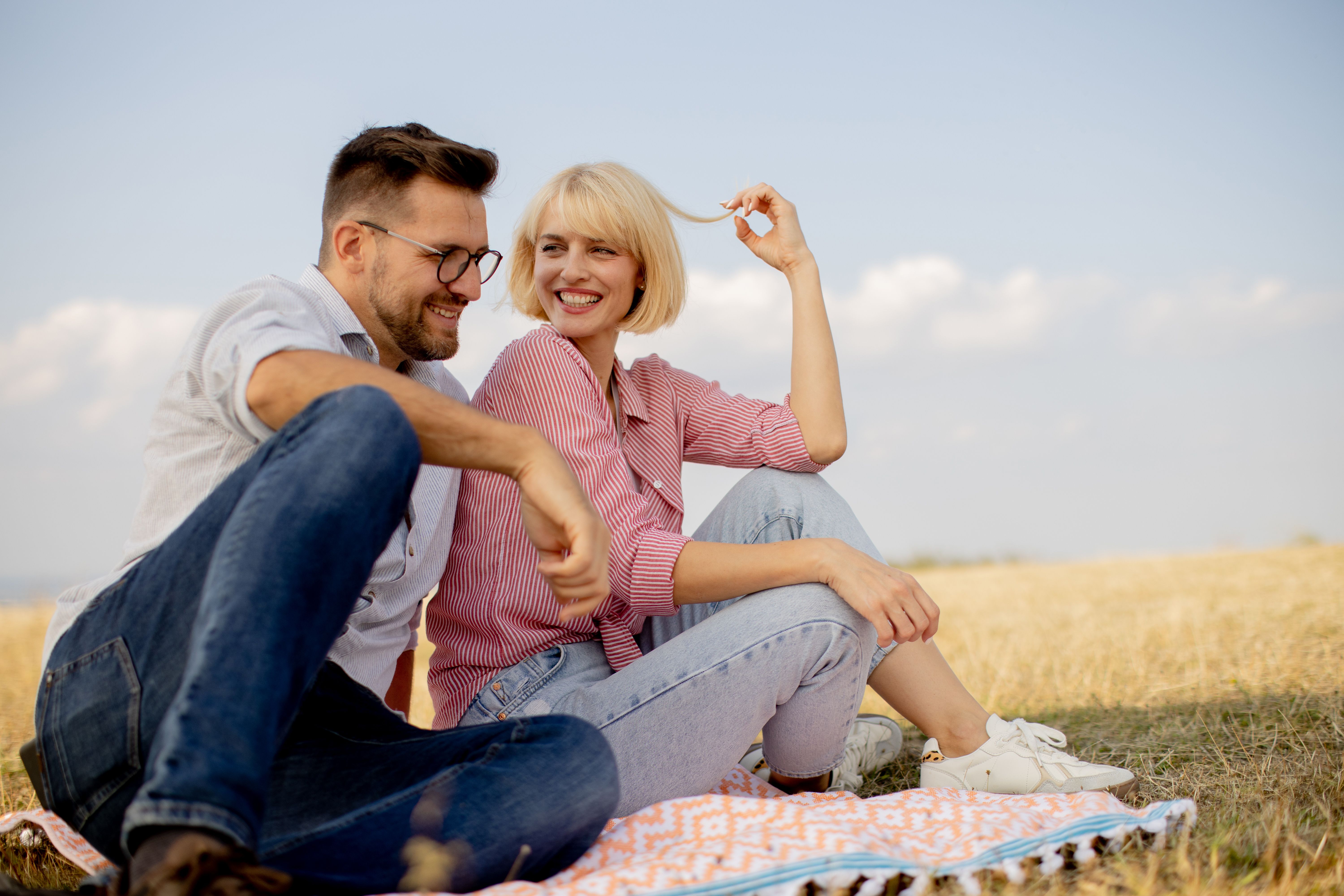 Couple enjoying a sunny afternoon on a blanket in a golden field