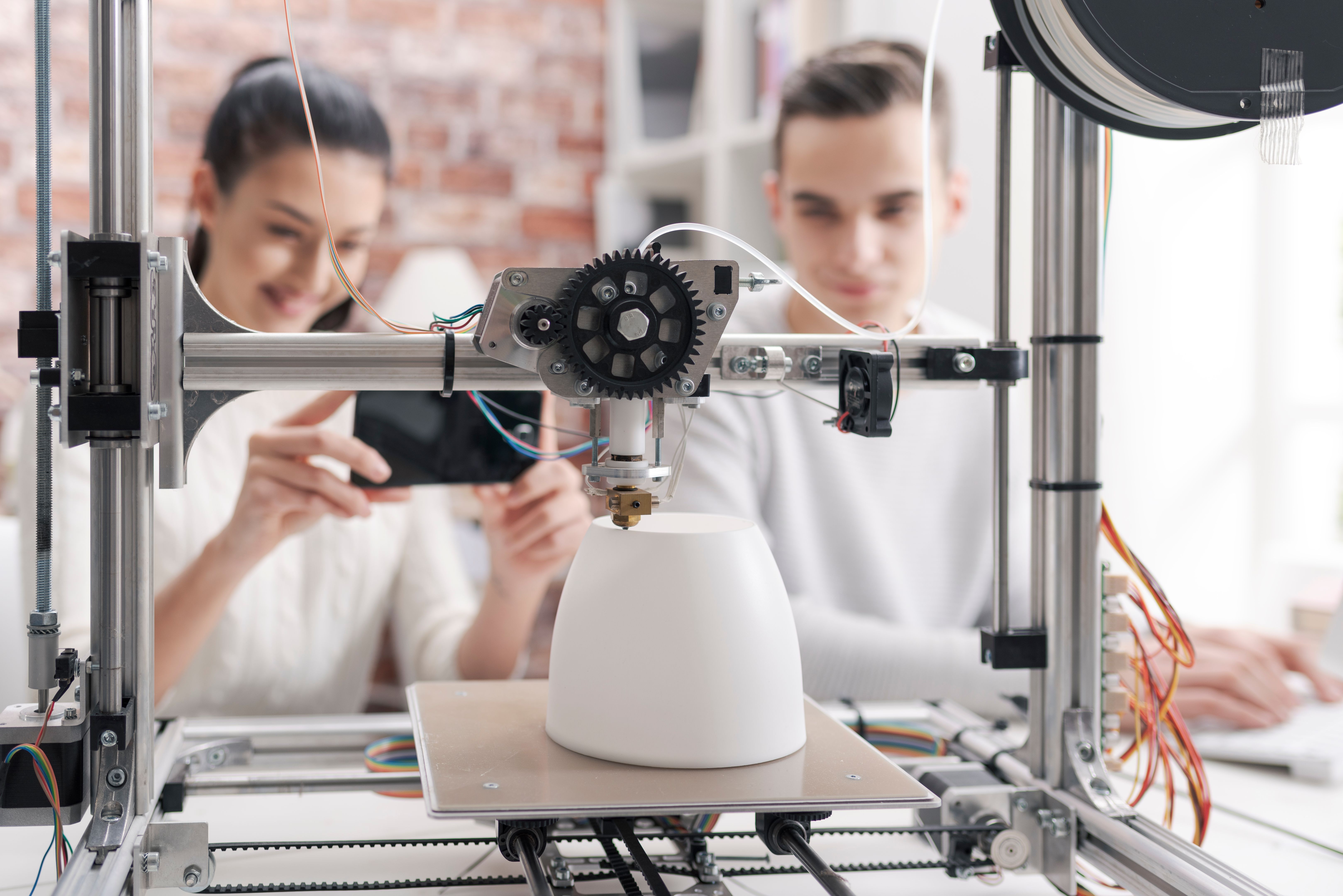 Academic students using a 3D printer in the lab Academic students using a 3D printer in the lab