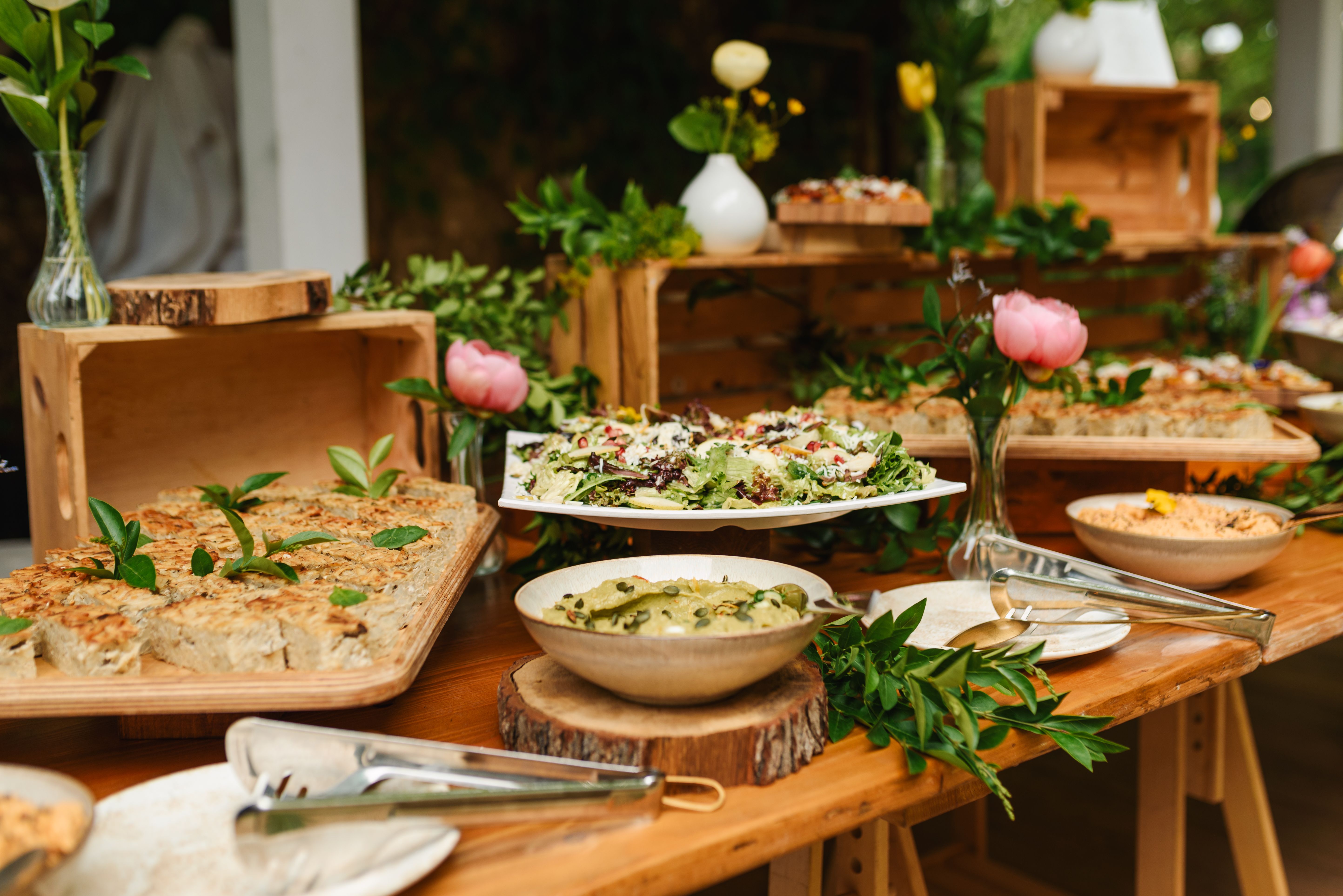 Buffet food for party decorated with fresh plants.