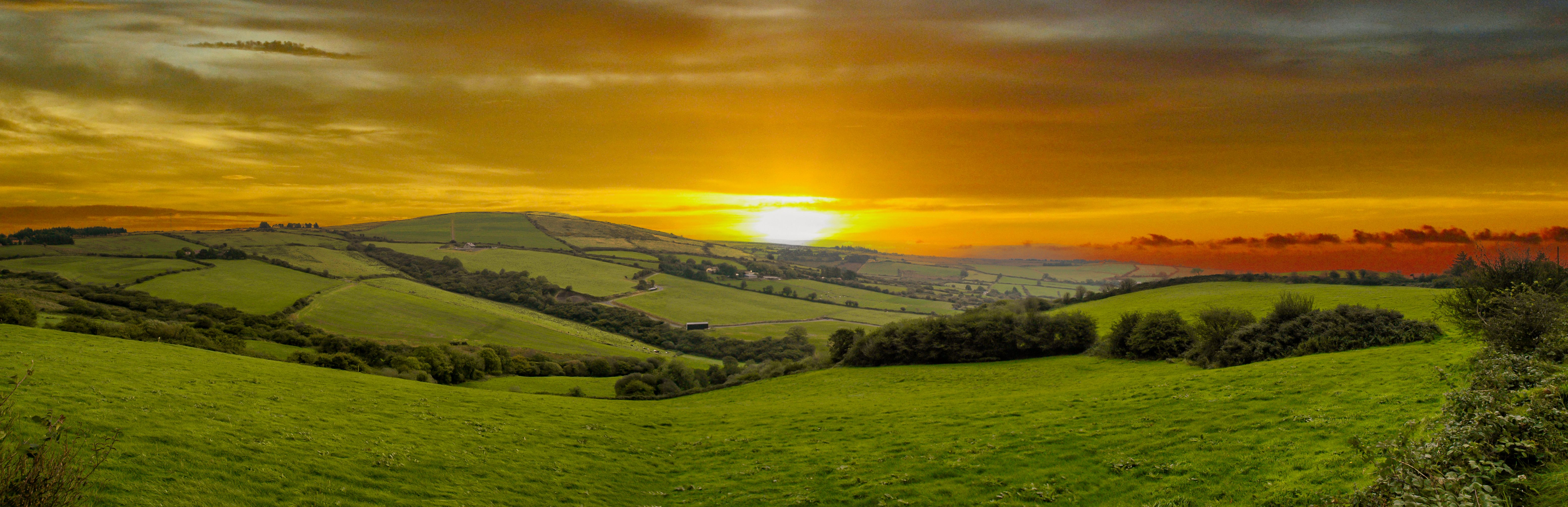 View of endless lush pastures and farmlands of Ireland. Beautiful Irish countryside with green fields and meadows. Rural landscape