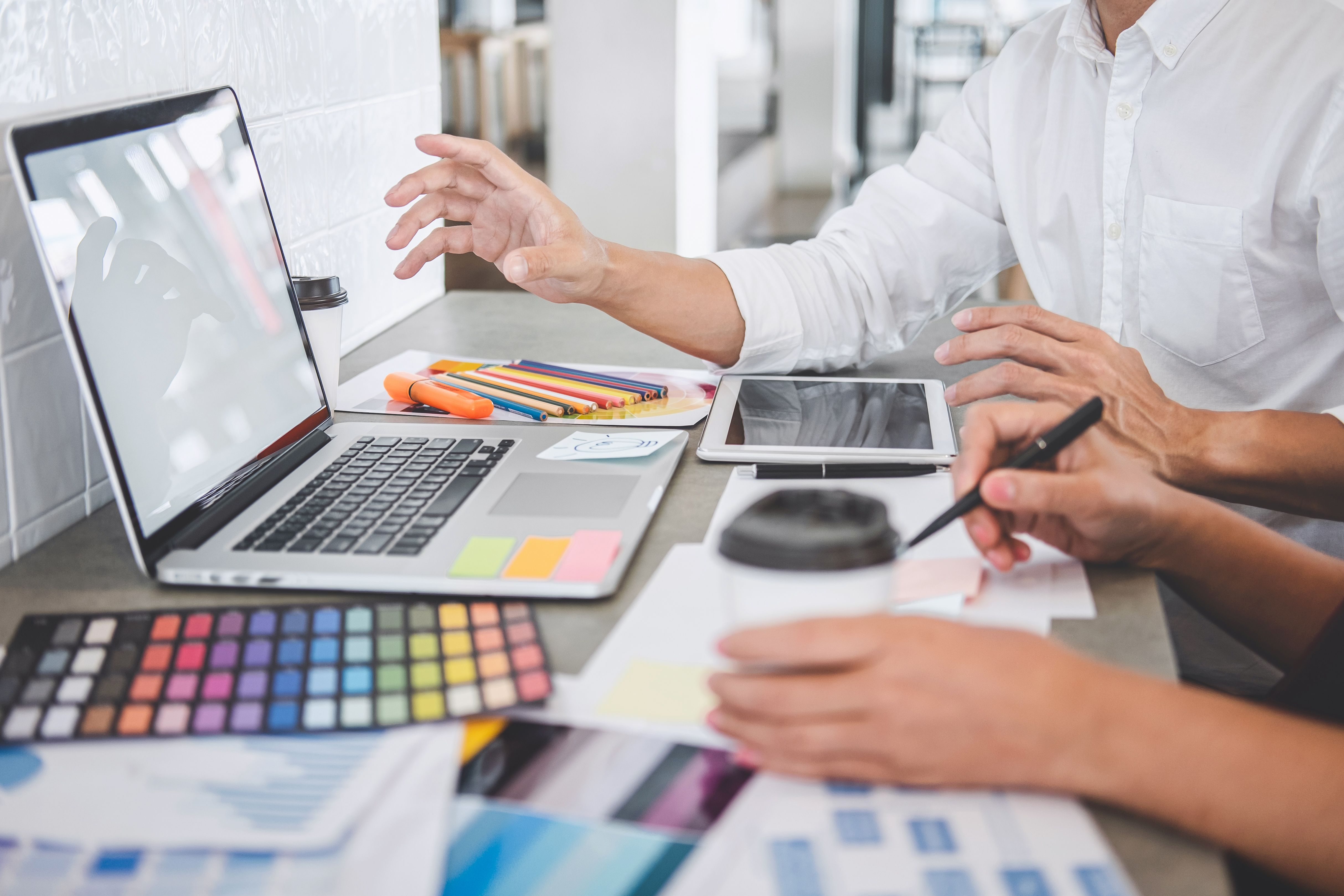 Sección media de diseñadores gráficos trabajando en la mesa
