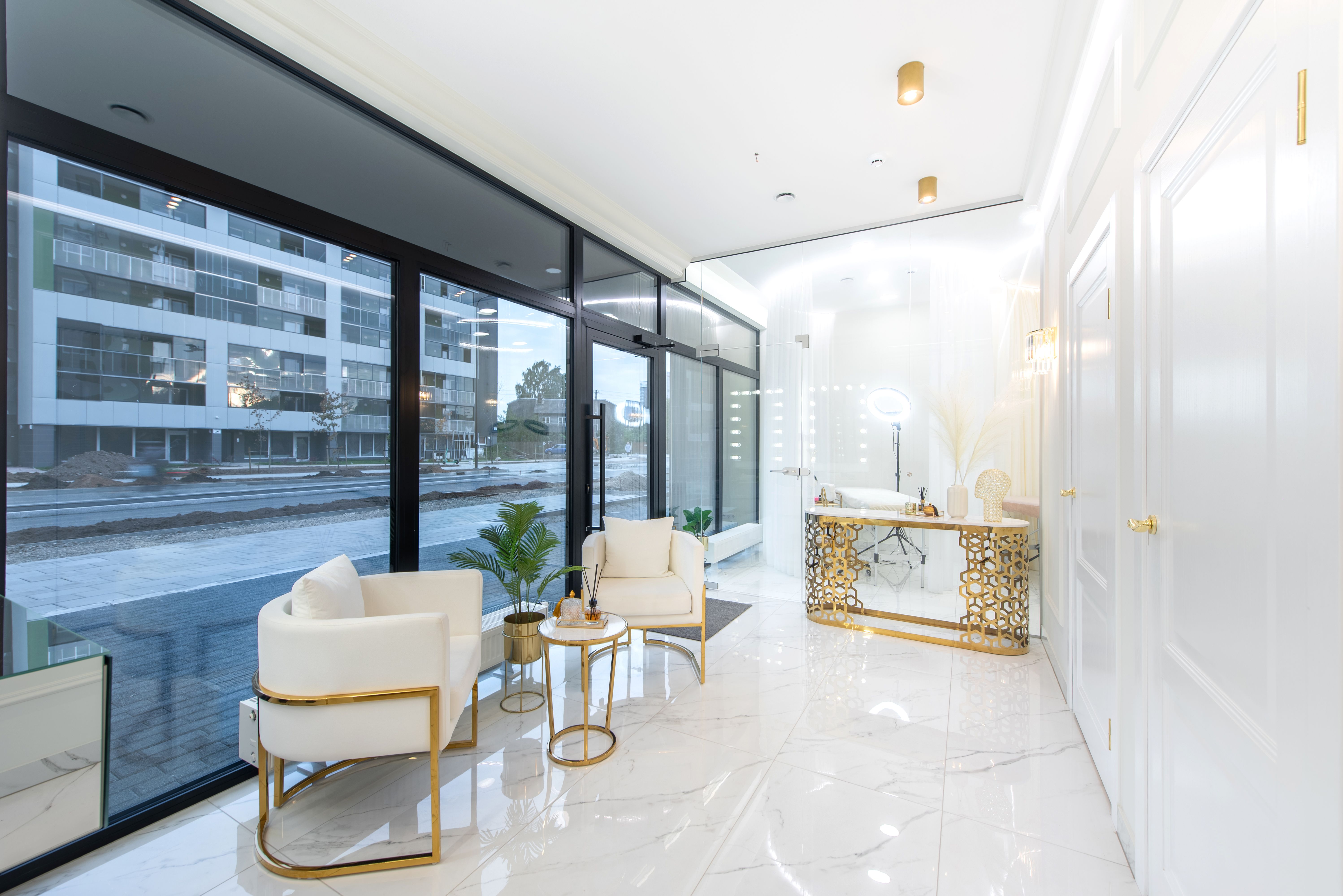 Elegant Modern Beauty Salon Office Lounge with Gold Accents and Large Glass Windows
