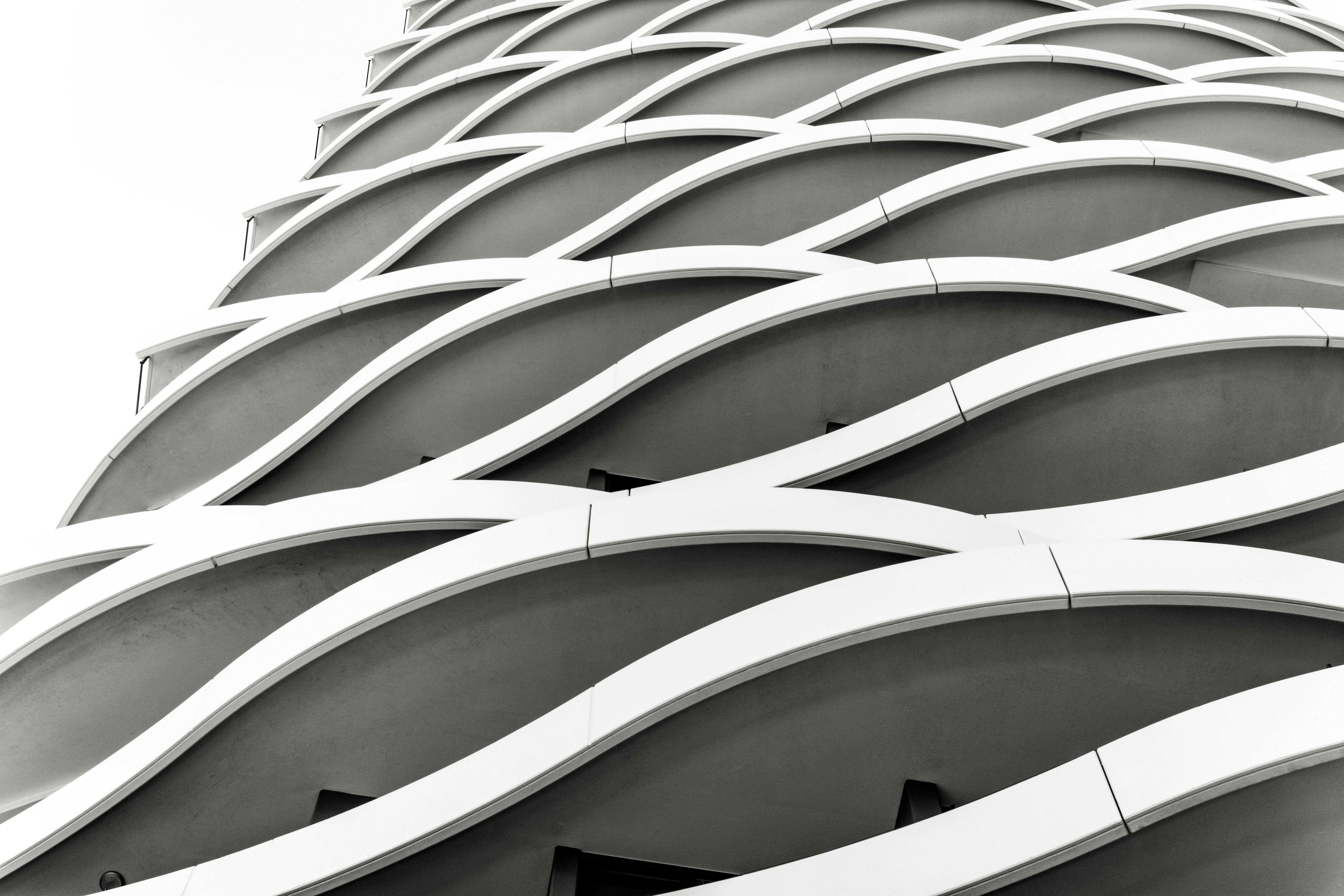 Black and white closeup low angle view of modern corporate building, background with copy space