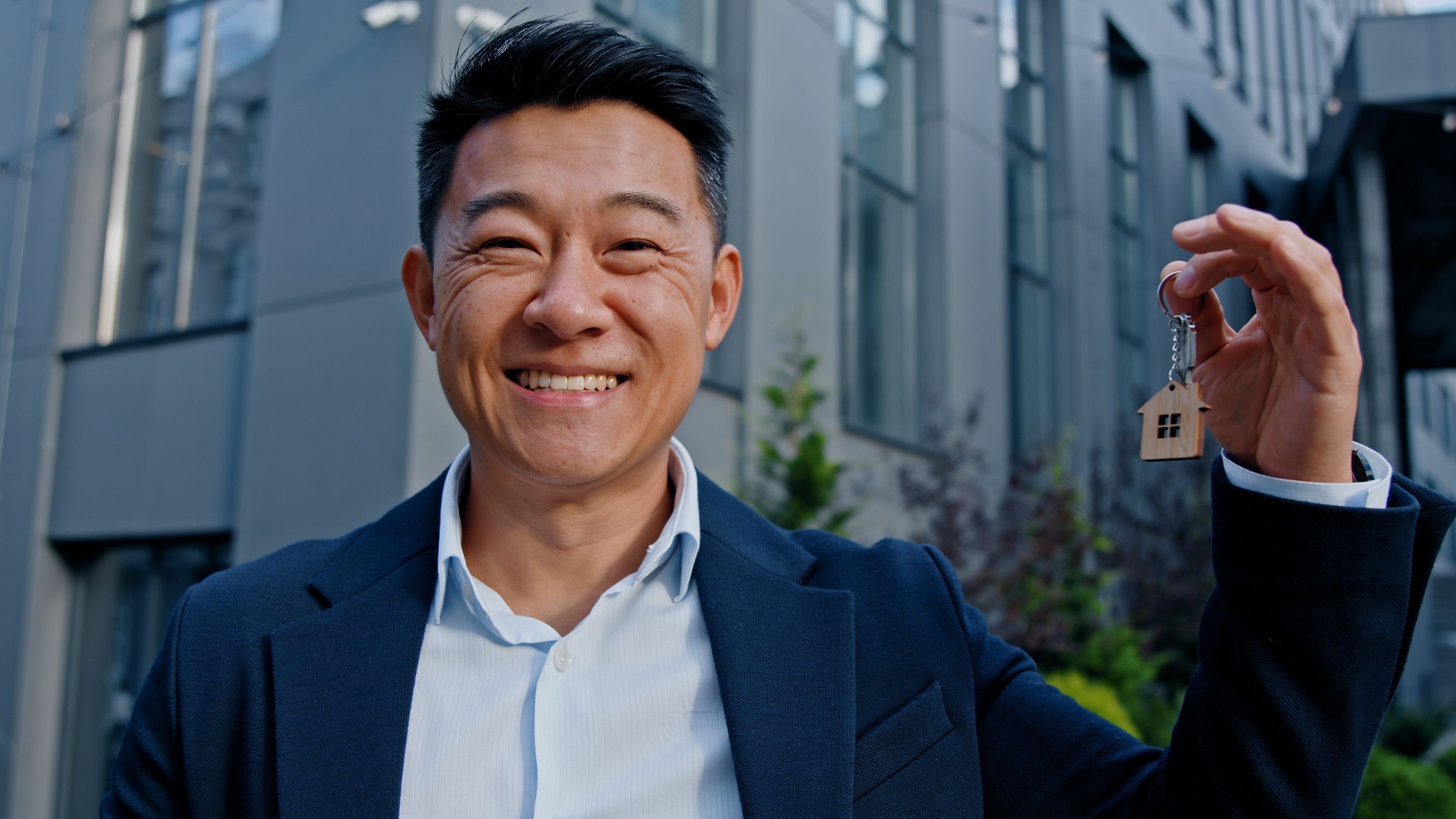 Happy smiling Asian adult 40s man holding keys portrait outdoors win reaction victory celebrate male real estate agent real estate agent investor buyer selling property new building office dwelling skyscrapers Happy smiling Asian adult 40s man holding keys portrait outdoors win reaction victory celebrate male real estate agent real estate agent investor buyer selling property new building office dwelling skyscrapers