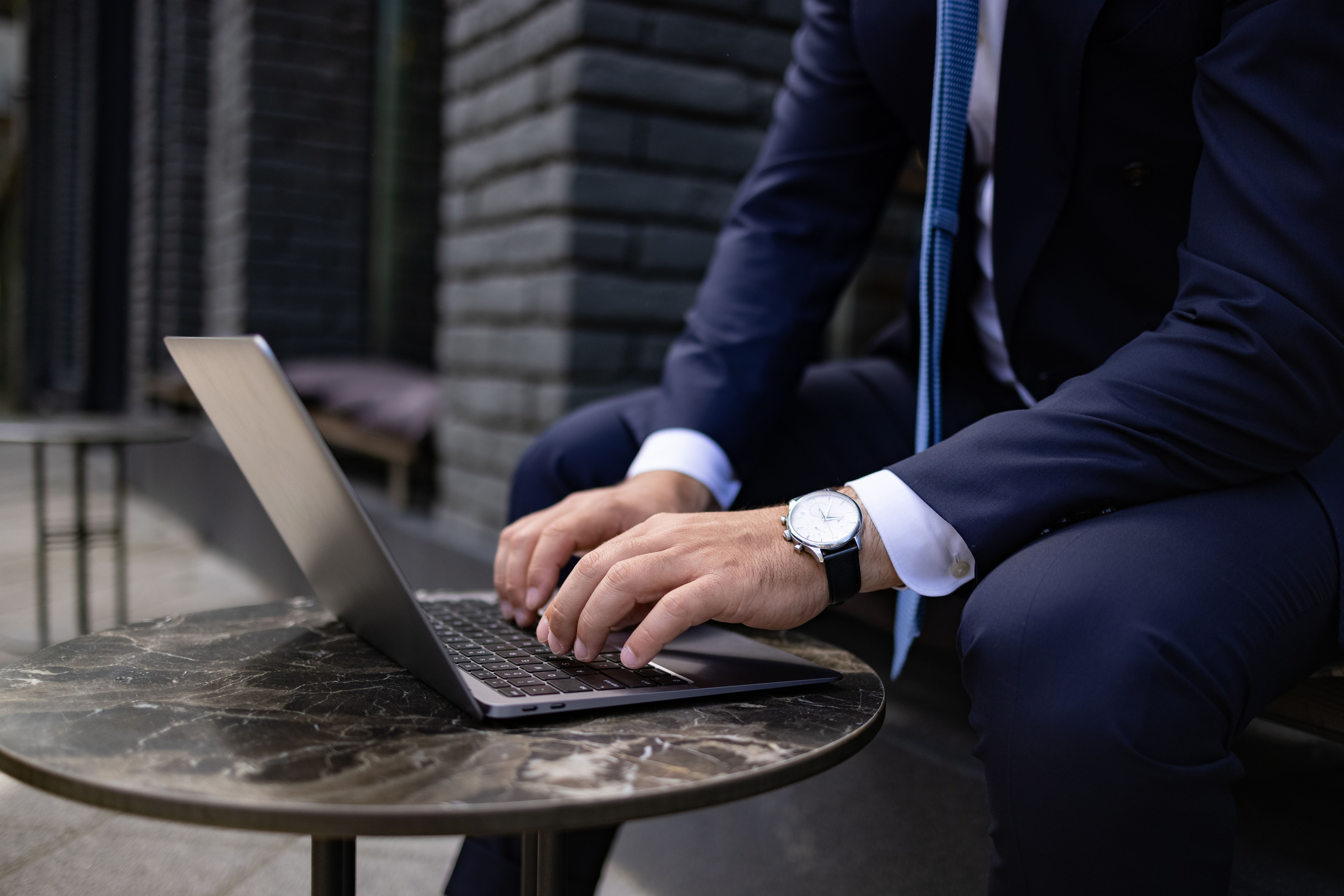 Close up side view of the hands of an unrecognizable Caucasian businessman working using a laptop Close up side view of the hands of an unrecognizable Caucasian businessman working using a laptop