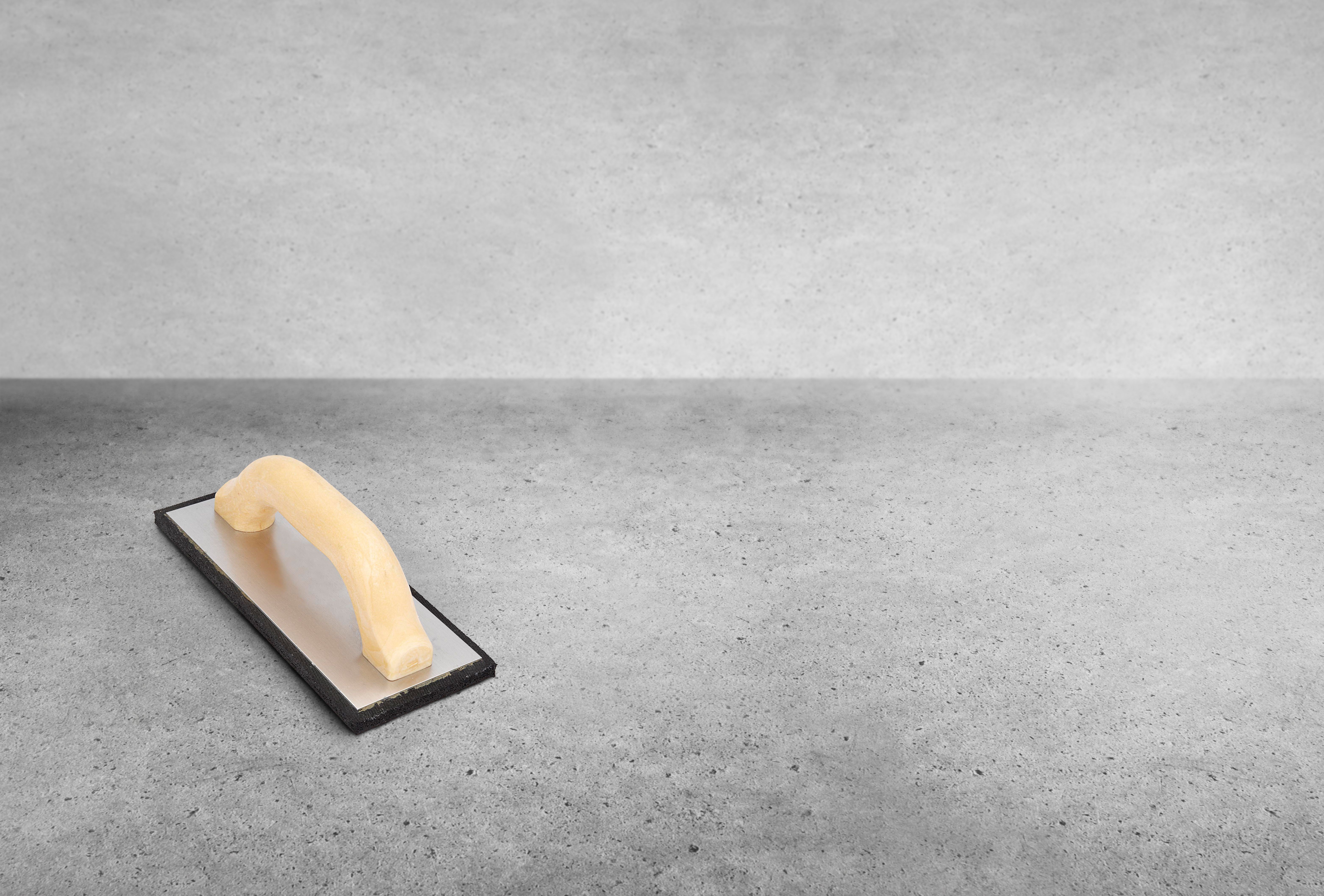 Almohadilla de espuma aplicadora de lechada de baldosas sobre fondo de hormigón Almohadilla de espuma aplicadora de lechada de baldosas sobre fondo de hormigón