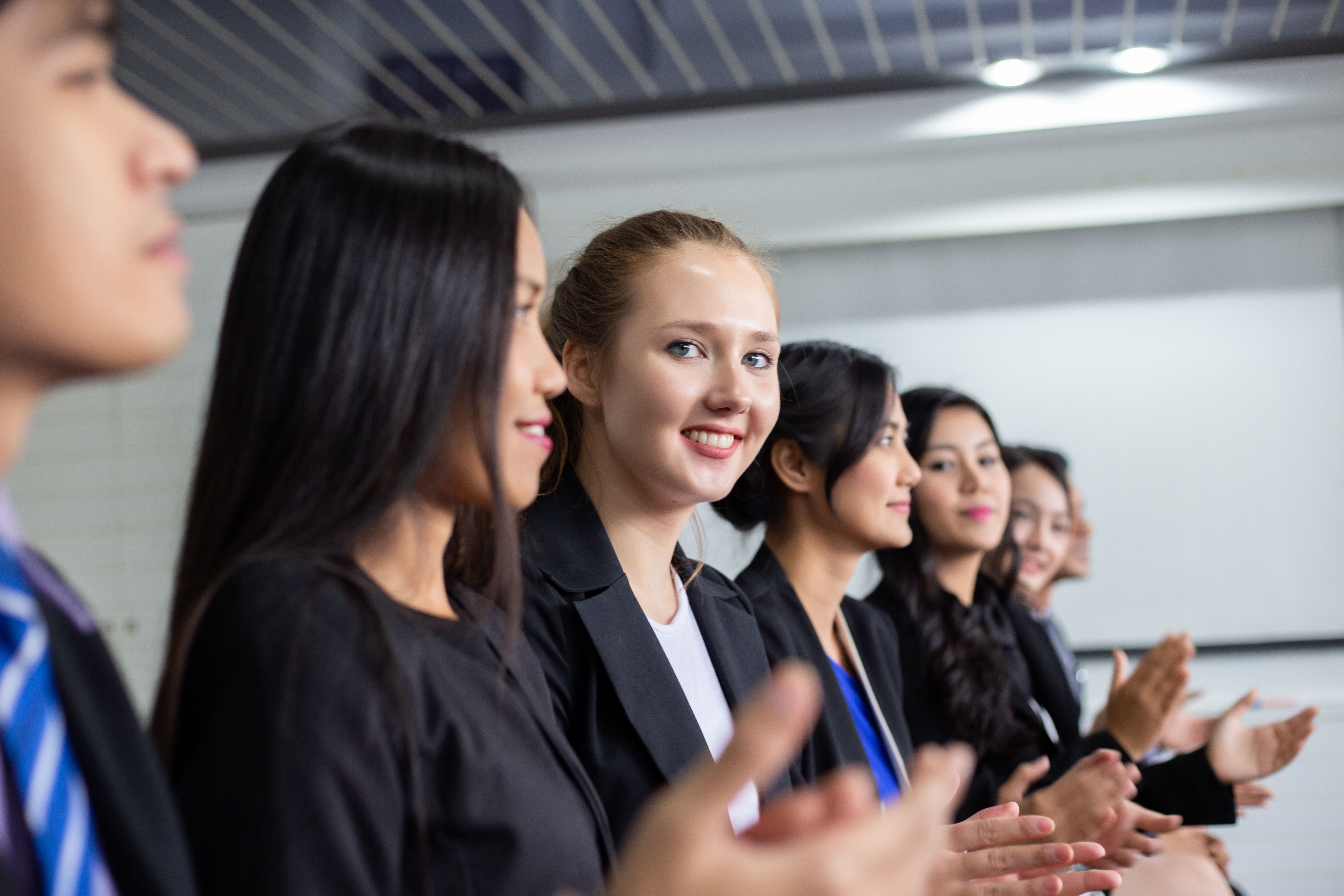 Businesswoman applauding at a seminar with colleagues