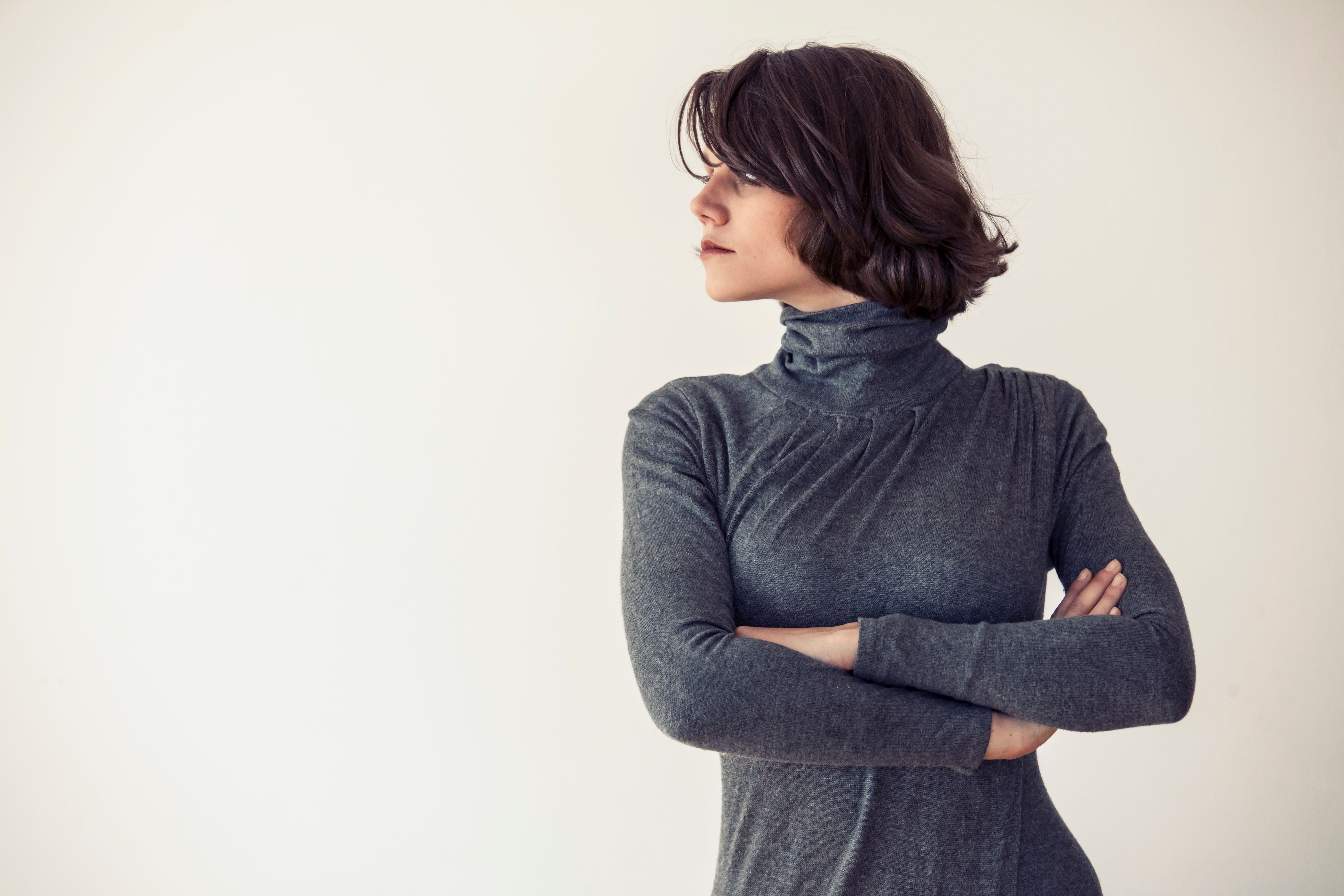Elegant young woman standing arms crossed