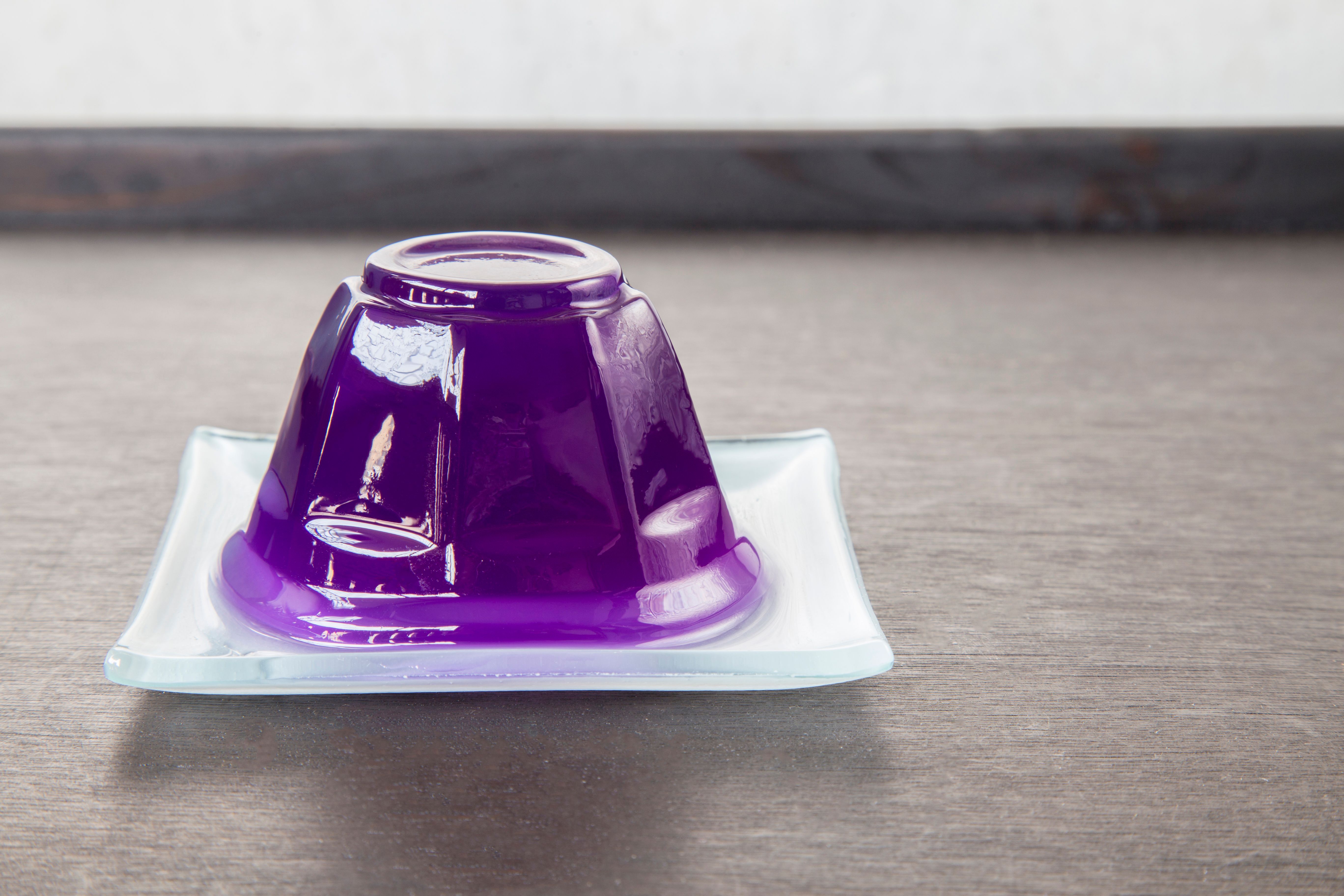 Purple grape jelly on dish on wooden background with copyspace. Purple grape jelly on dish on wooden background with copyspace.