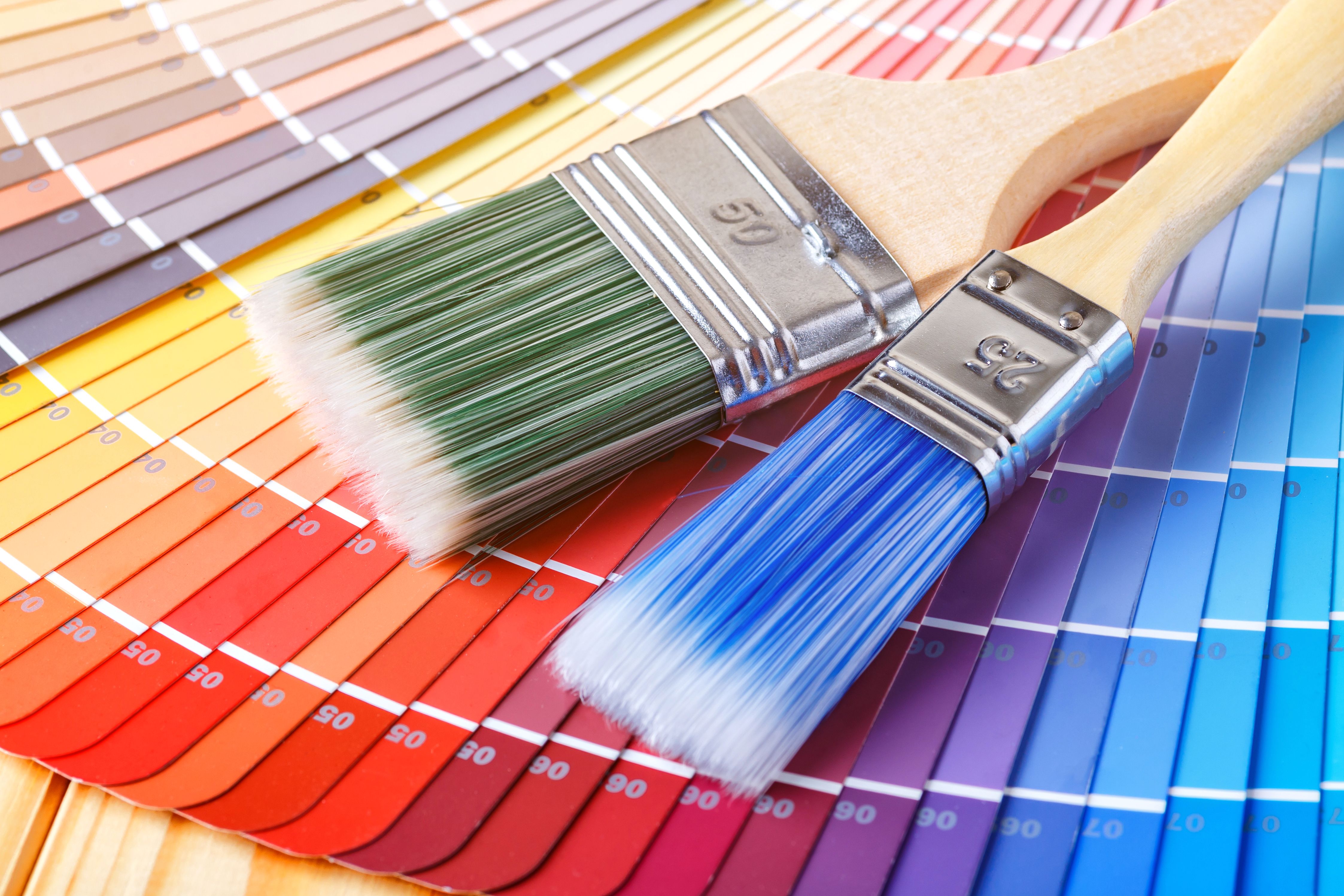 Painter and decorator work table with house project, color swatches, painting roller and paint brushes Painter and decorator work table with house project, color swatches, painting roller and paint brushes