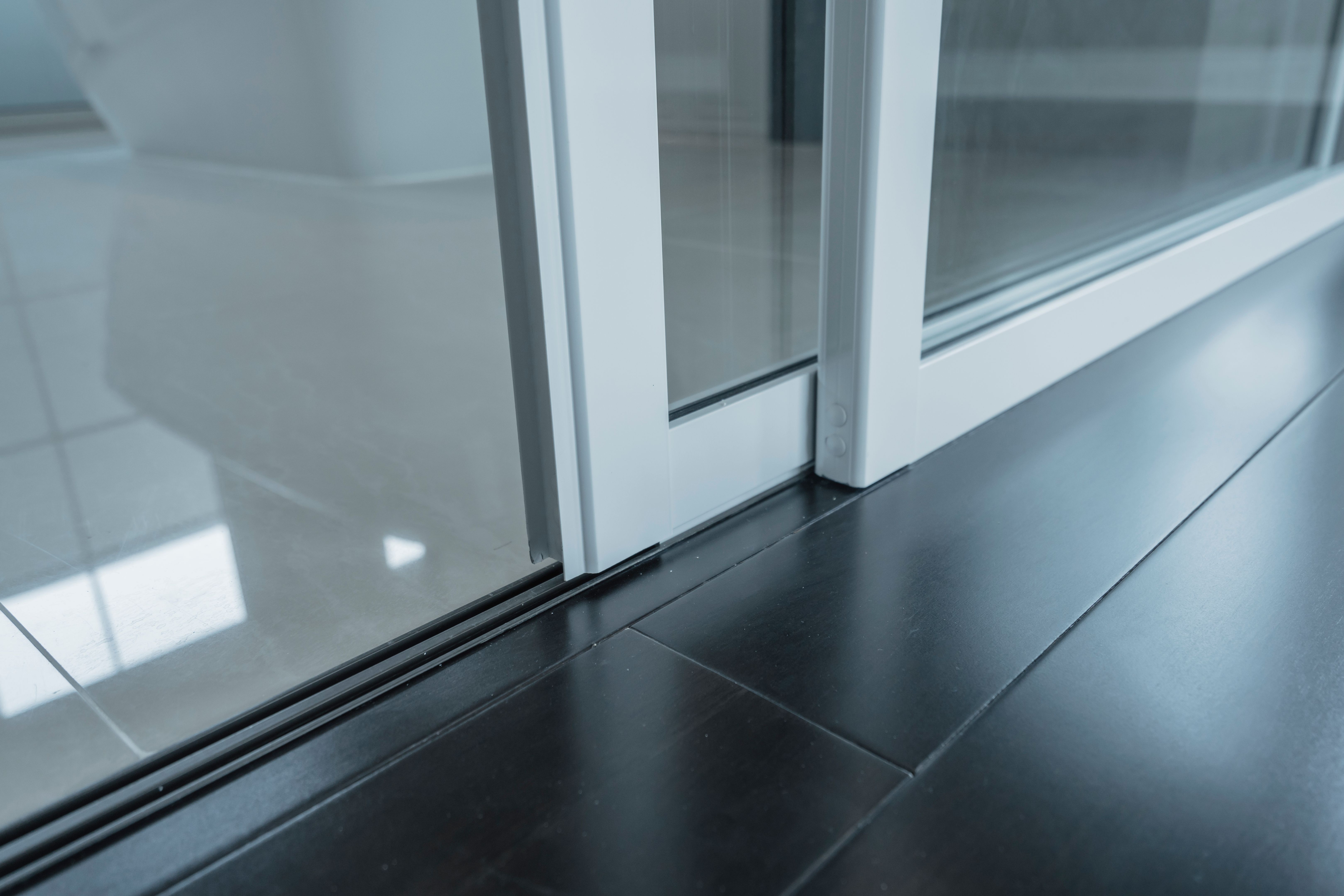detail of sliding door frame install with floor laminate and floor tile joint together