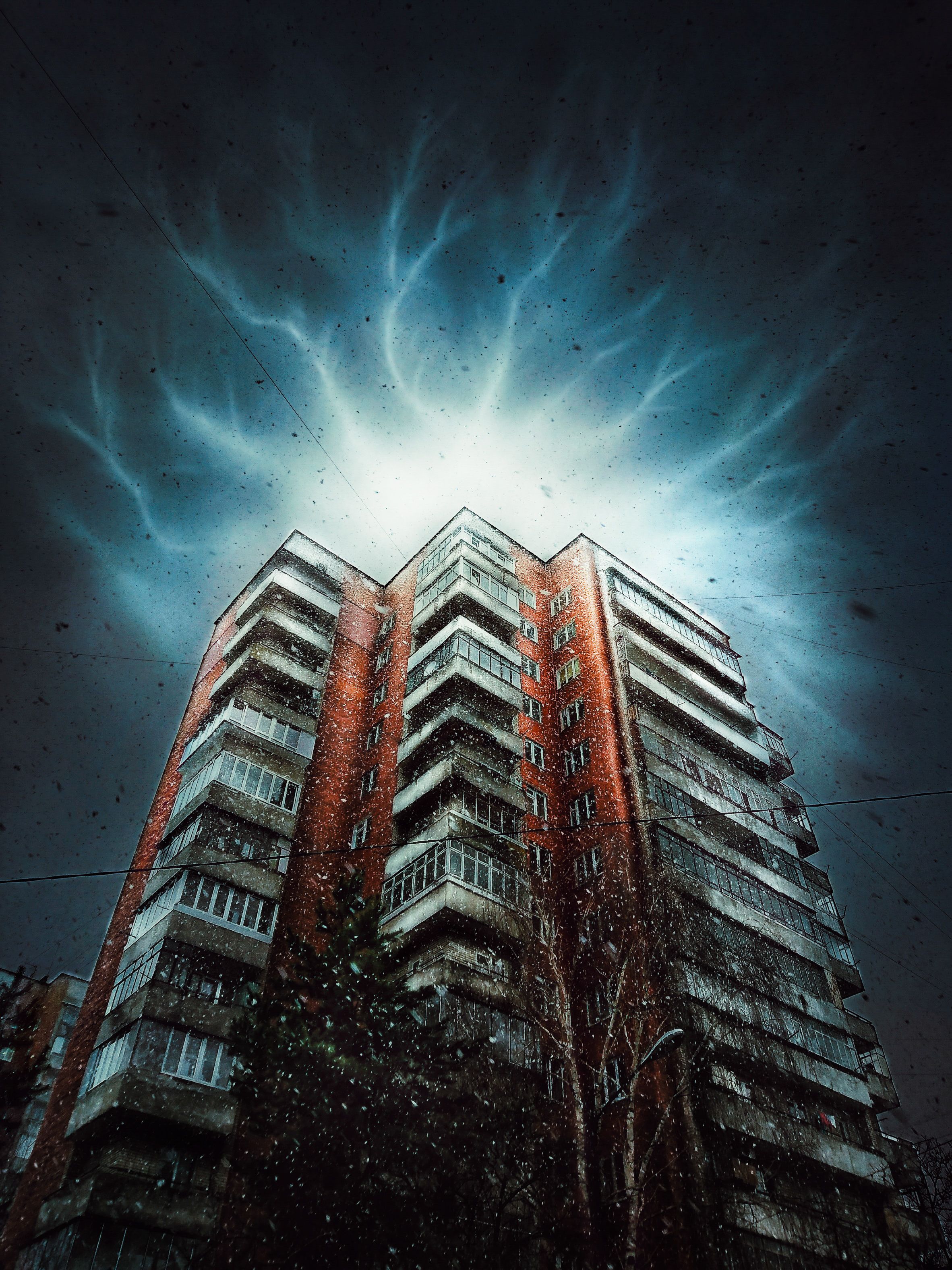 Lightning in the sky over an old tall house. Mysterious flashes of light over a high-rise building.