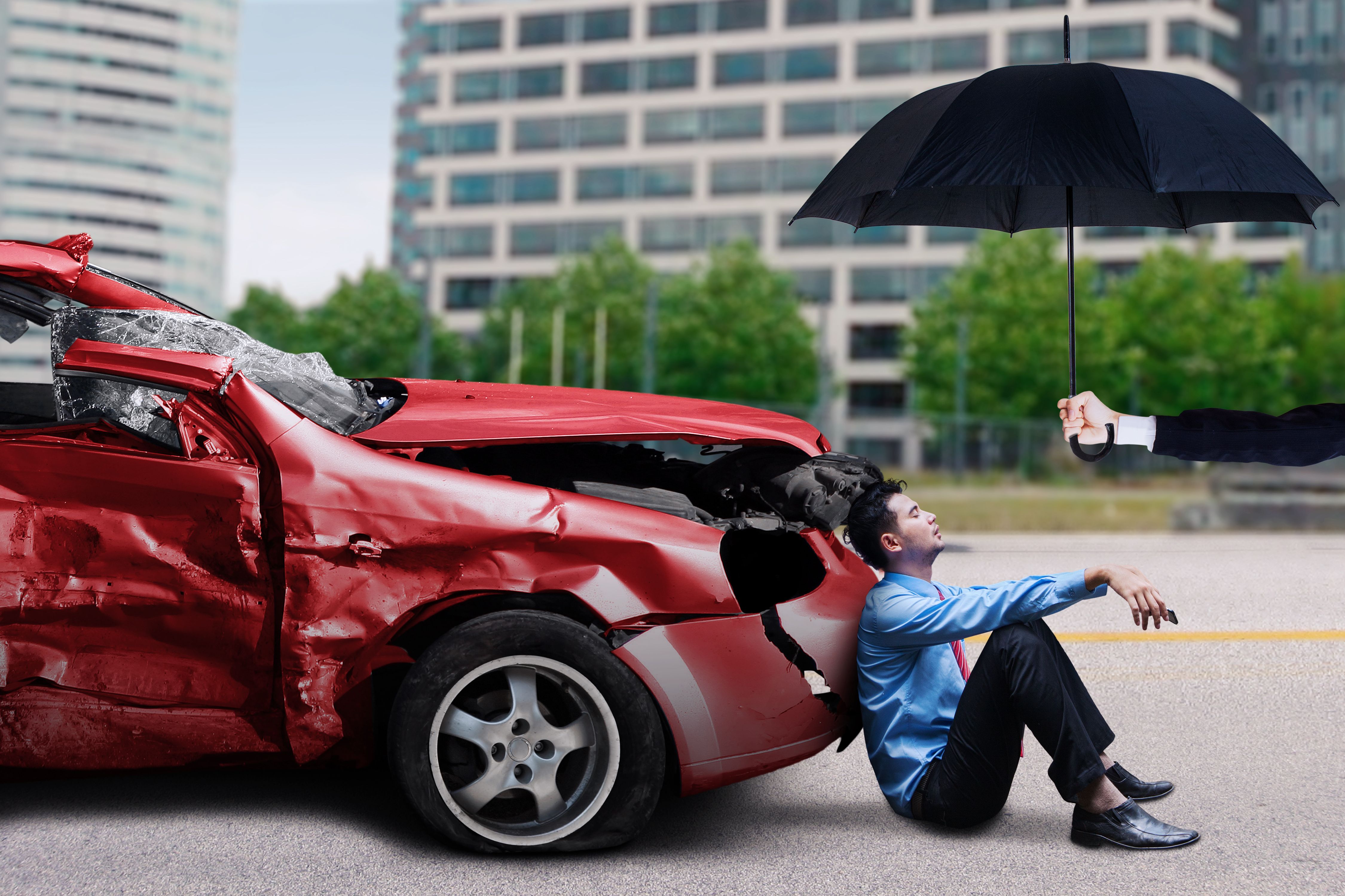 Man with damaged car sits under umbrella Man with damaged car sits under umbrella