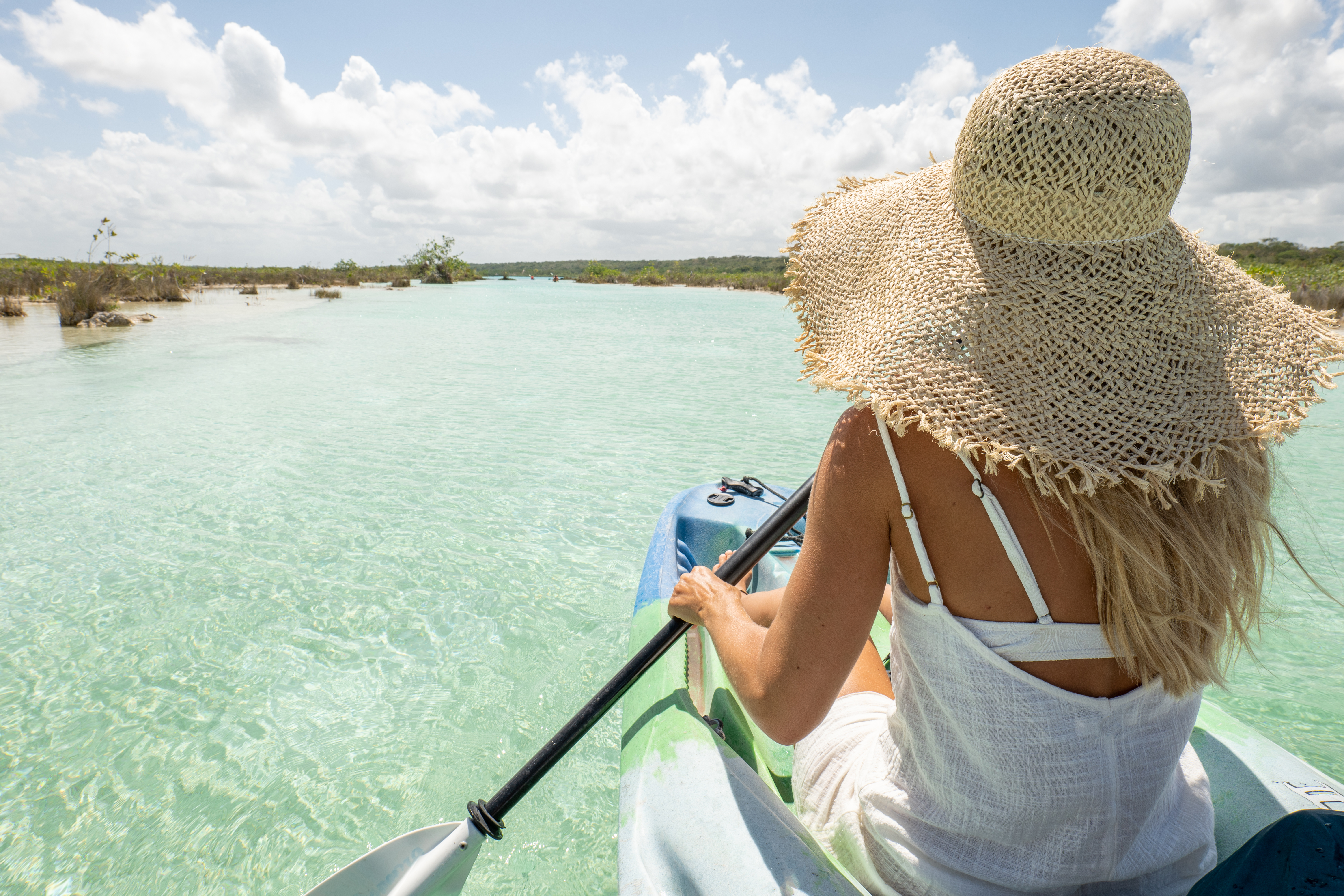 Rear view of woman canoeing on tropical lagoon