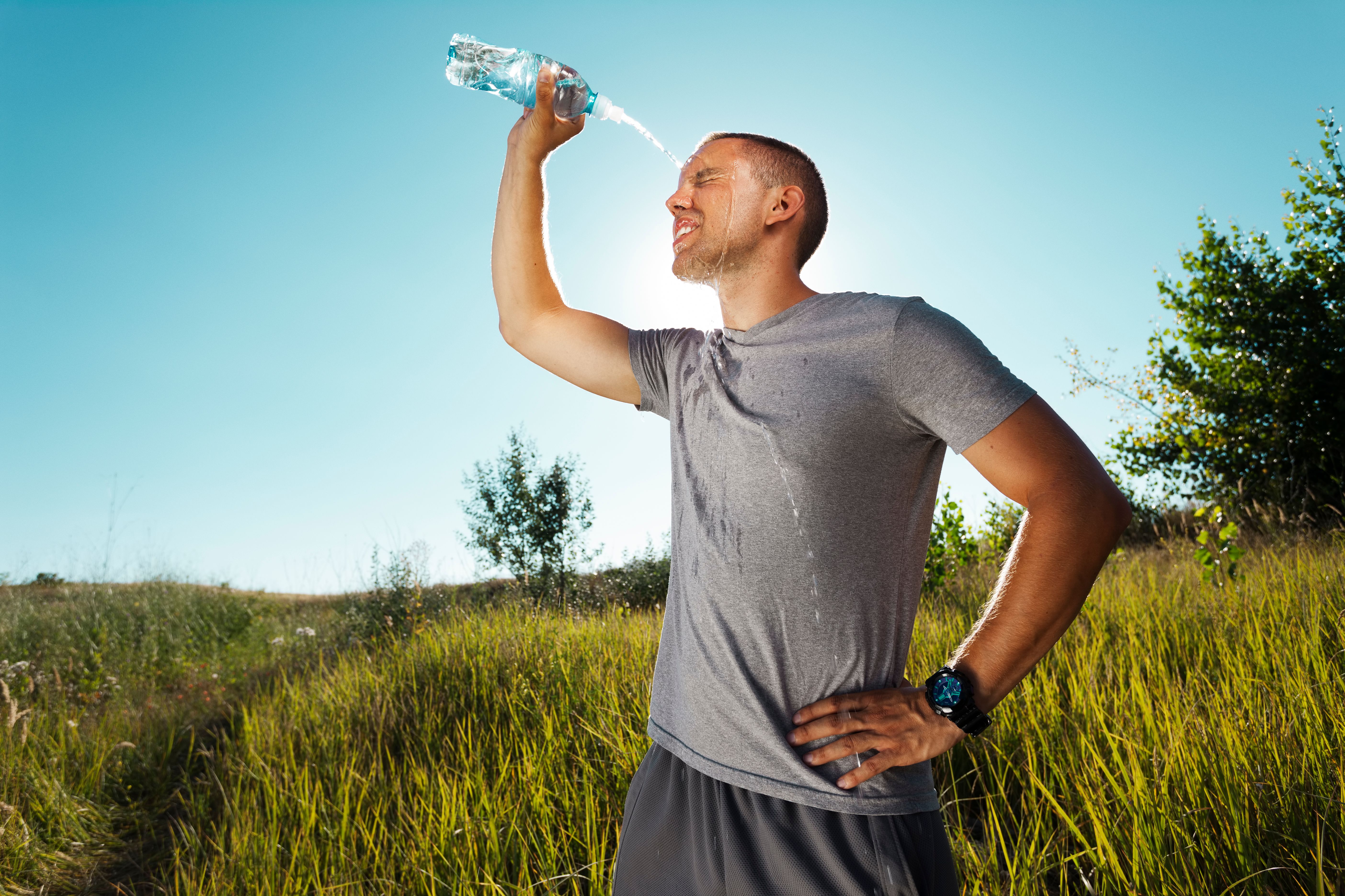 Young man refreshing himself with water