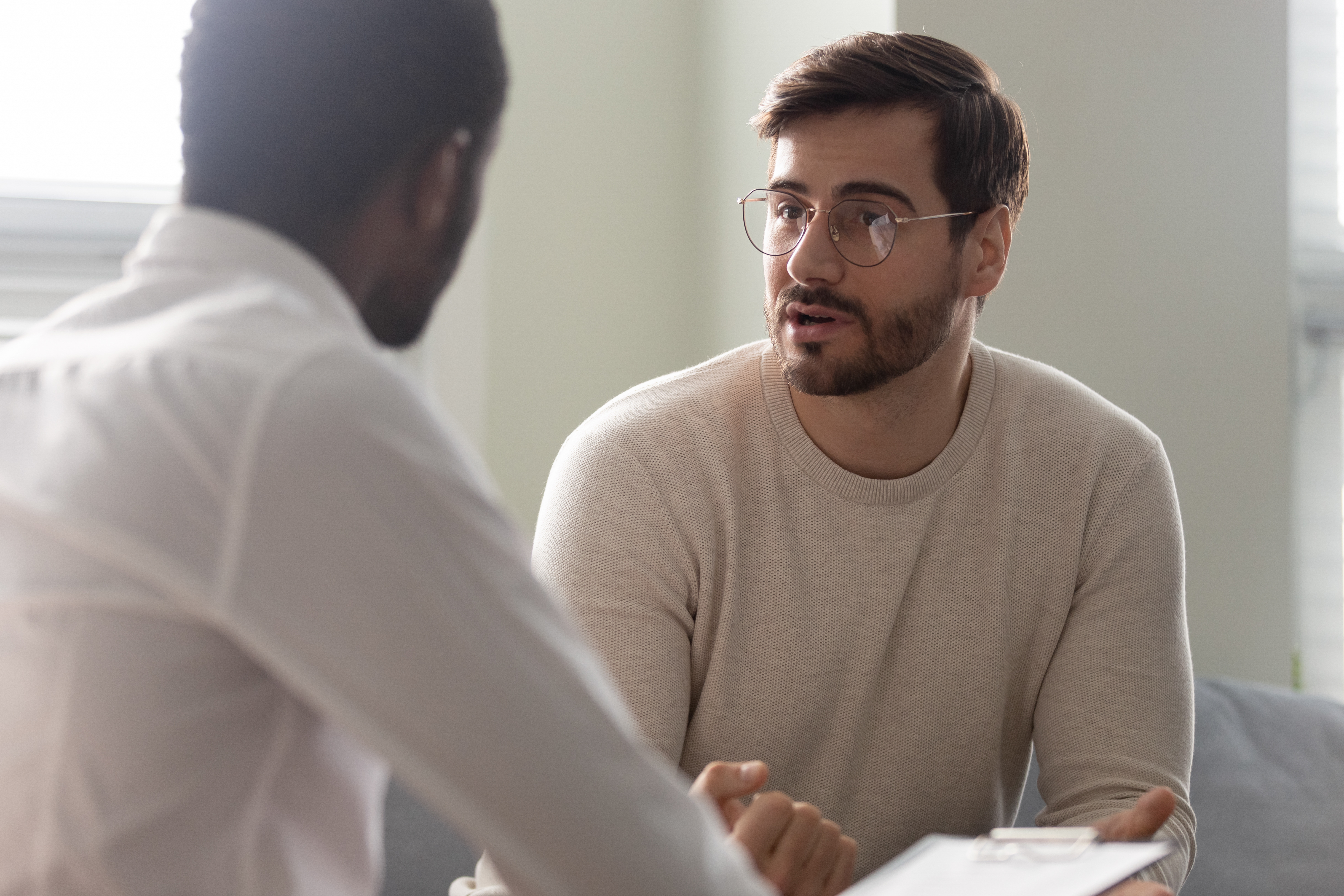 African counsellor sitting in front of patient listens his complaints African counsellor sitting in front of patient listens his complaints