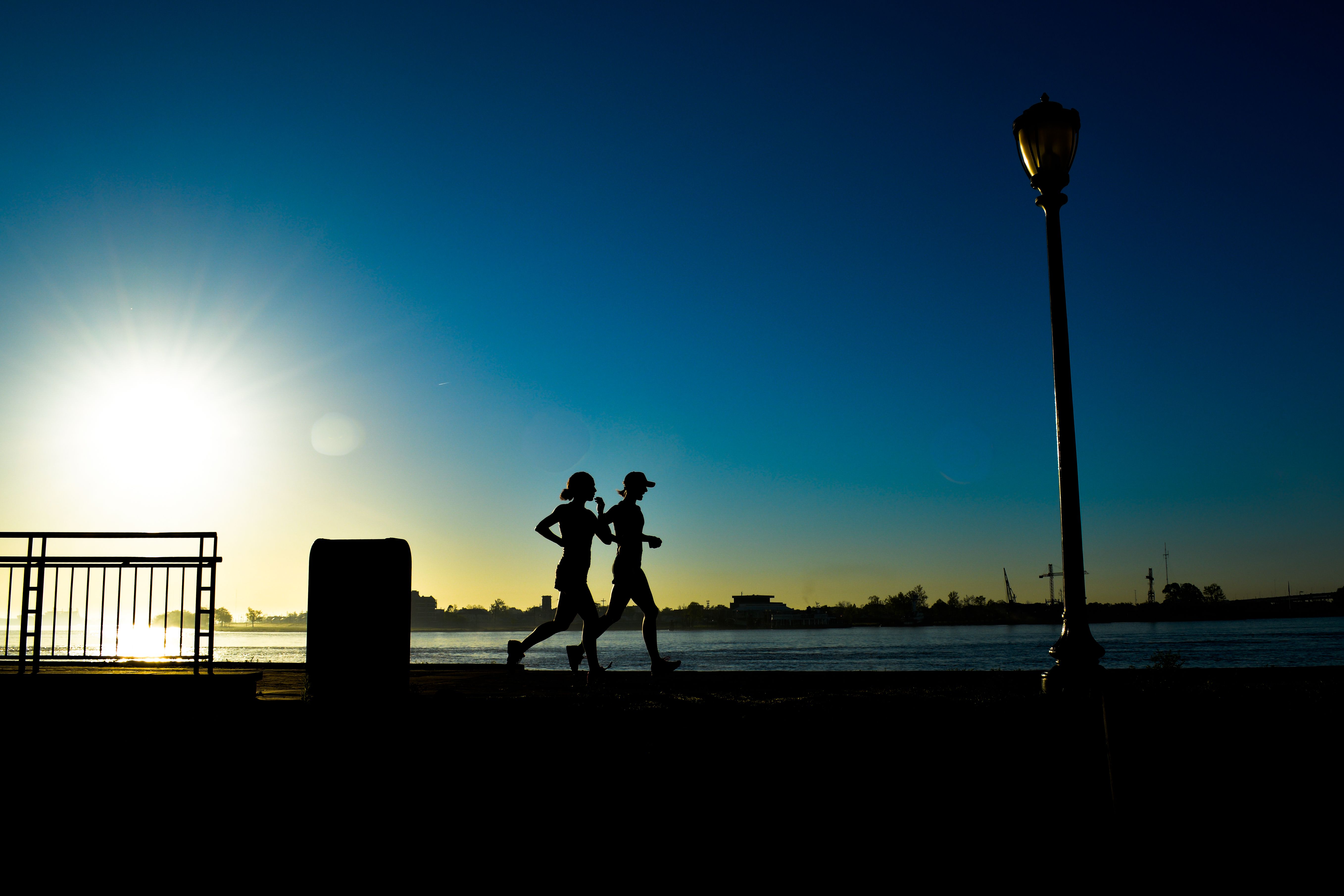 Silhouette of Joggers Along Mississippi Silhouette of Joggers Along Mississippi