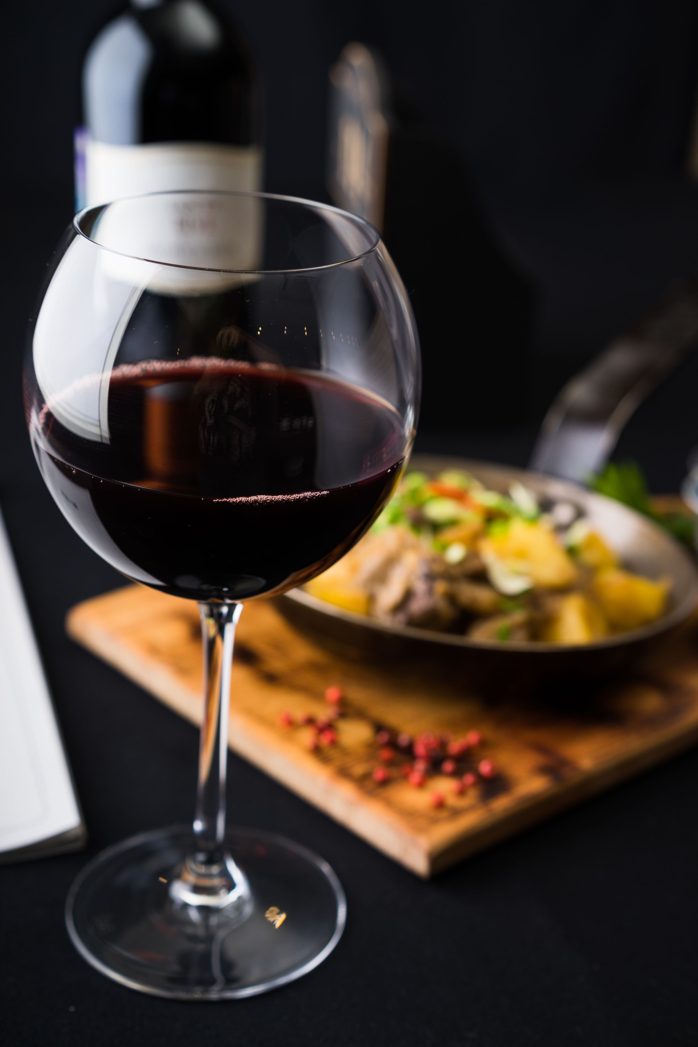glass of red wine in front of freshly cooked meat glass of red wine in front of freshly cooked meat