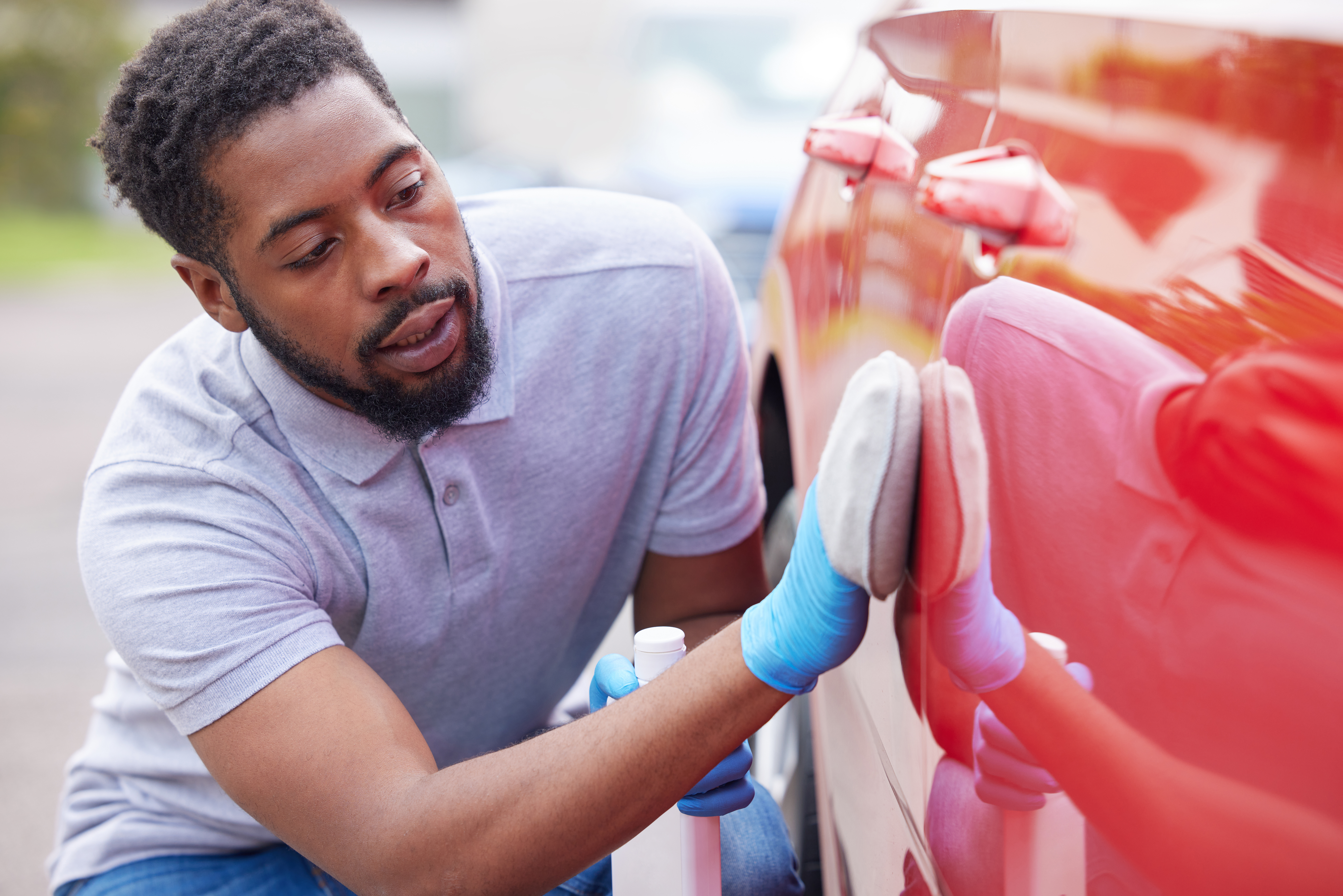 Man Polishing Bodywork Of Car During Valet Man Polishing Bodywork Of Car During Valet