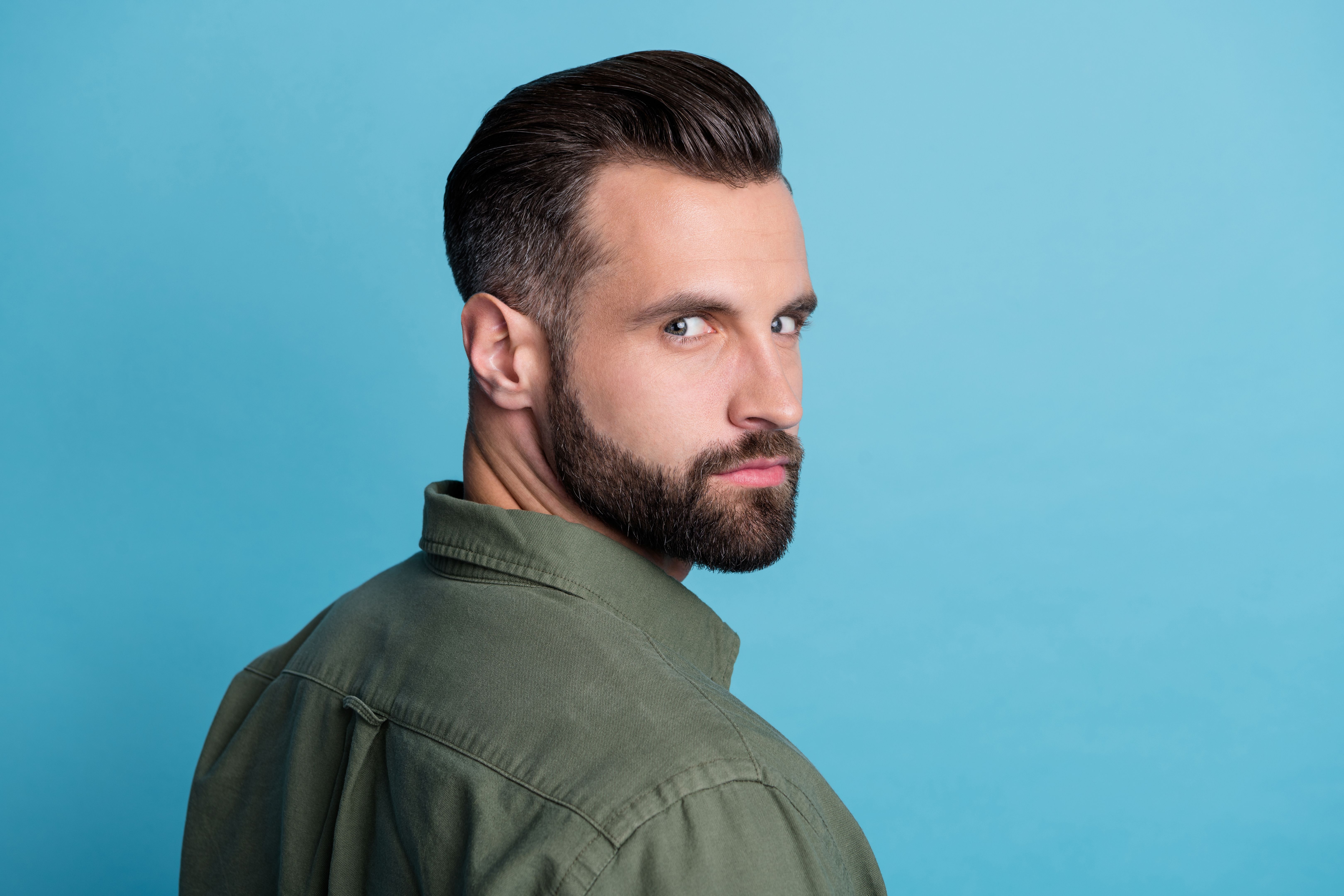 Back view photo of hot attractive guy barbershop model gel lotion brown hair isolated on blue color background
