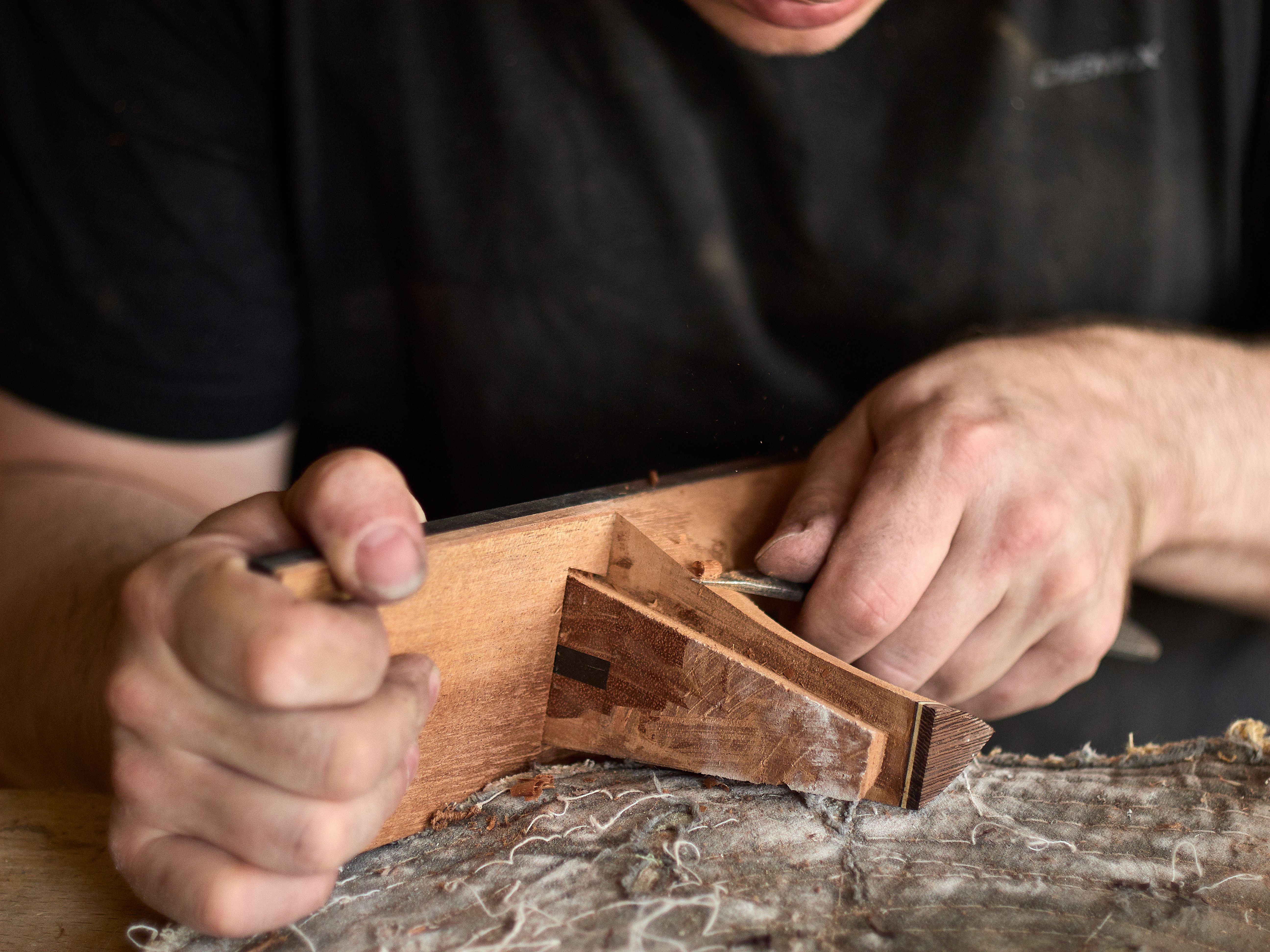 luthier is working on the neck of a classical guitar.