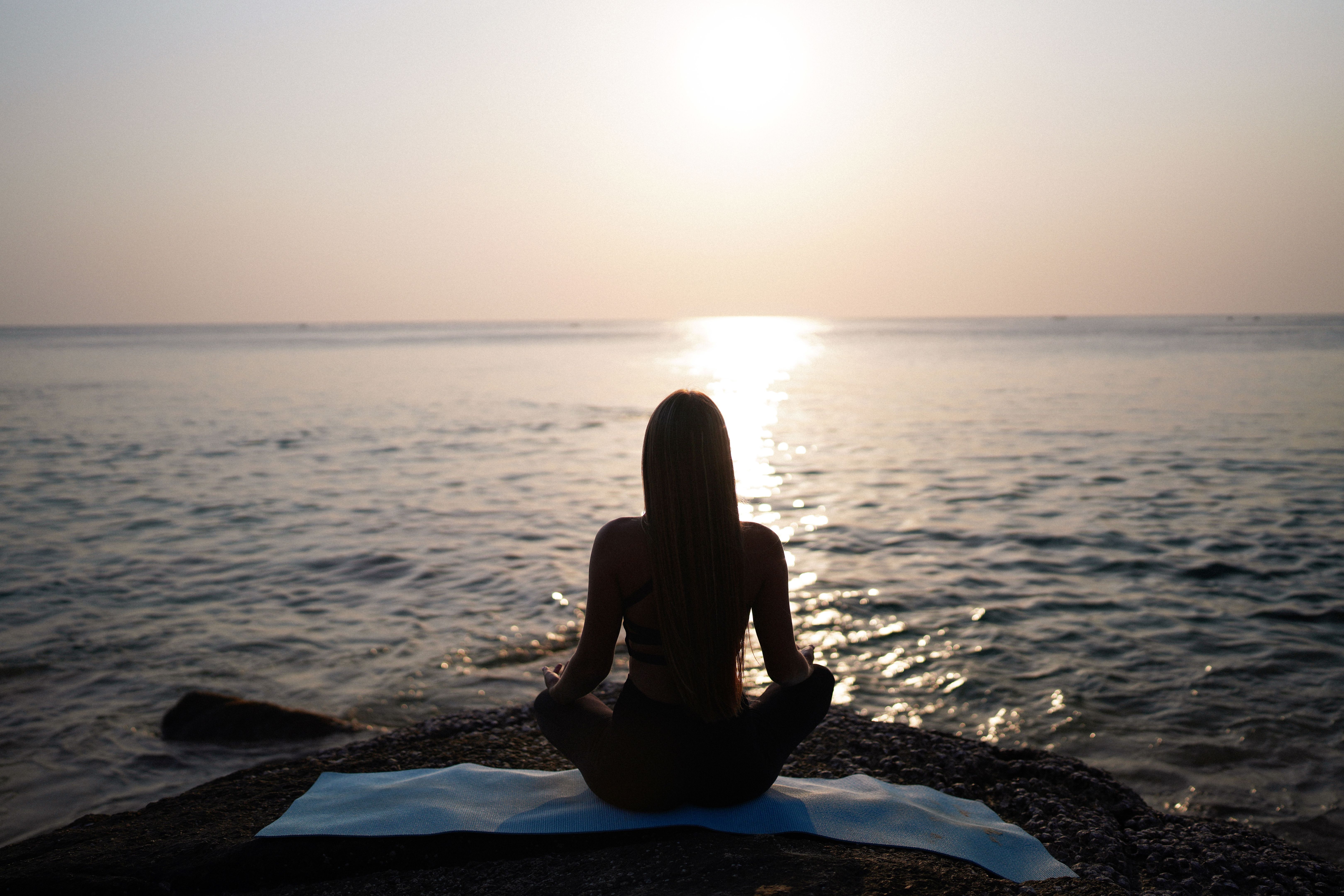 Silhouette of young woman doing yoga at sunset Silhouette of young woman doing yoga at sunset