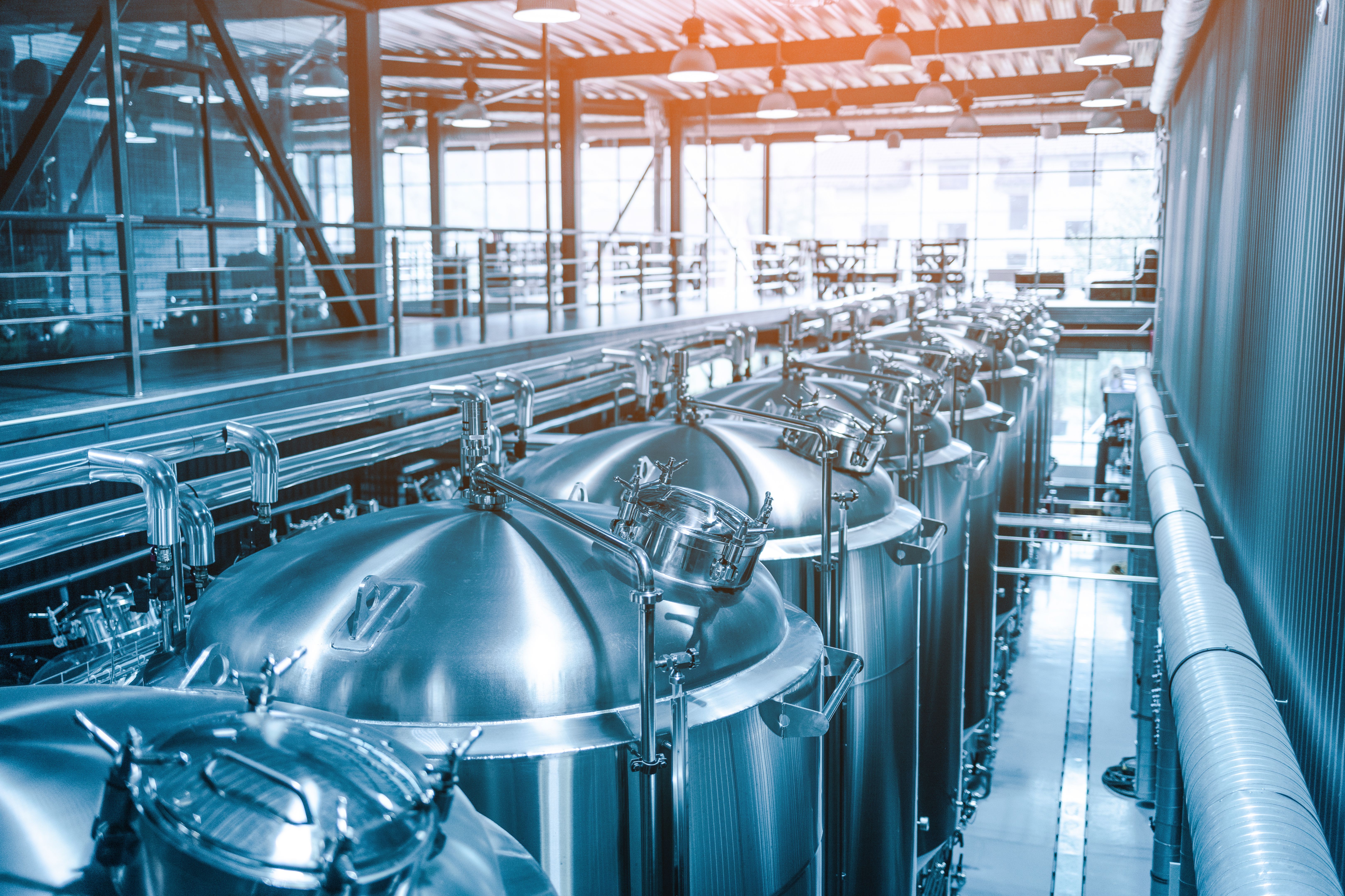 Private microbrewery. Modern beer plant with brewering kettles, tubes and tanks made of stainless steel Private microbrewery. Modern beer plant with brewering kettles, tubes and tanks made of stainless steel