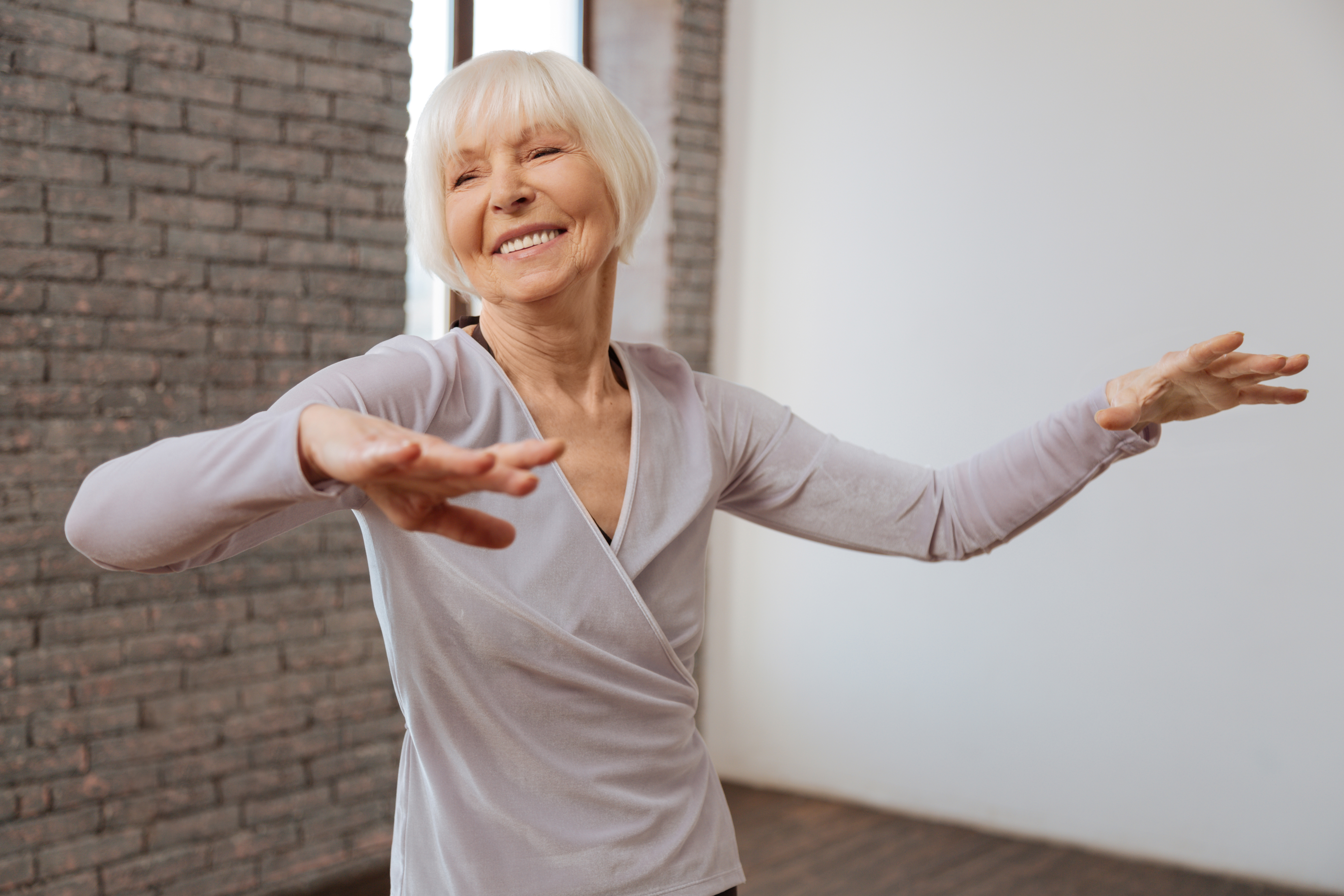 Smiling aged woman studying classical dance at the ballroom Smiling aged woman studying classical dance at the ballroom